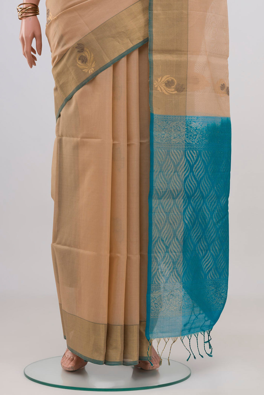 Pleats and pallu of Cream Silk Cotton Saree with Zari And Thread Butta on the body and Zari Border. 