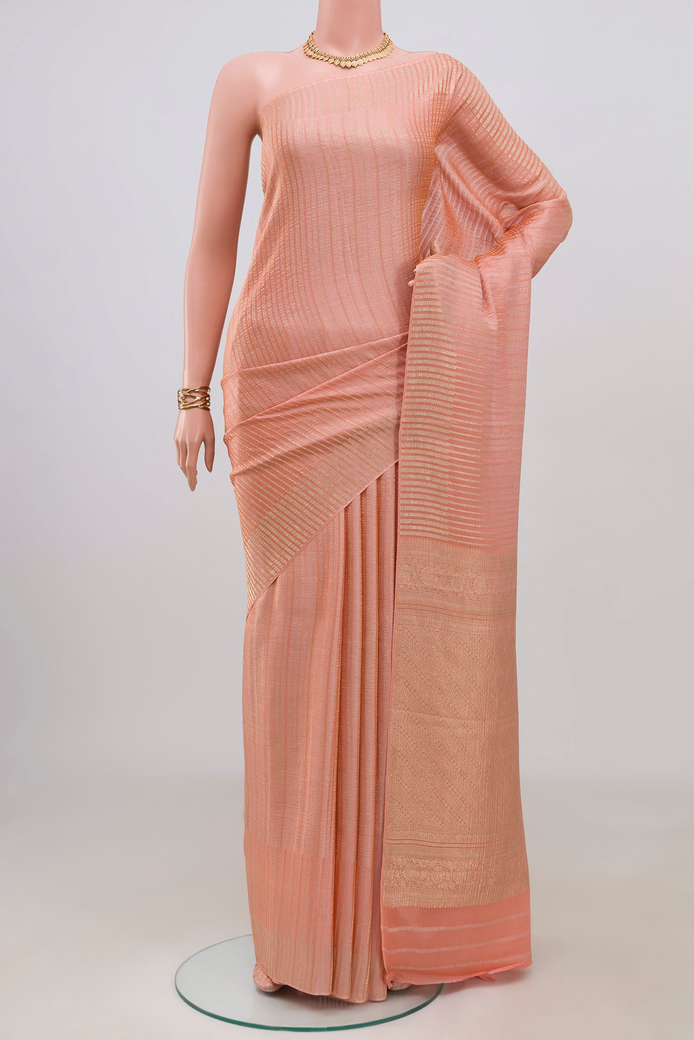 Peach Mysore Crepe Saree with Stripes on the body and Without Border.  displayed on a mannequin