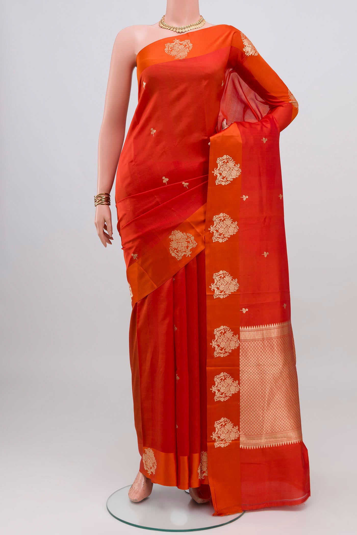 Orange Banarasi Katan Silk Saree with Zari Butta on the body and Zari Border.  displayed on a mannequin