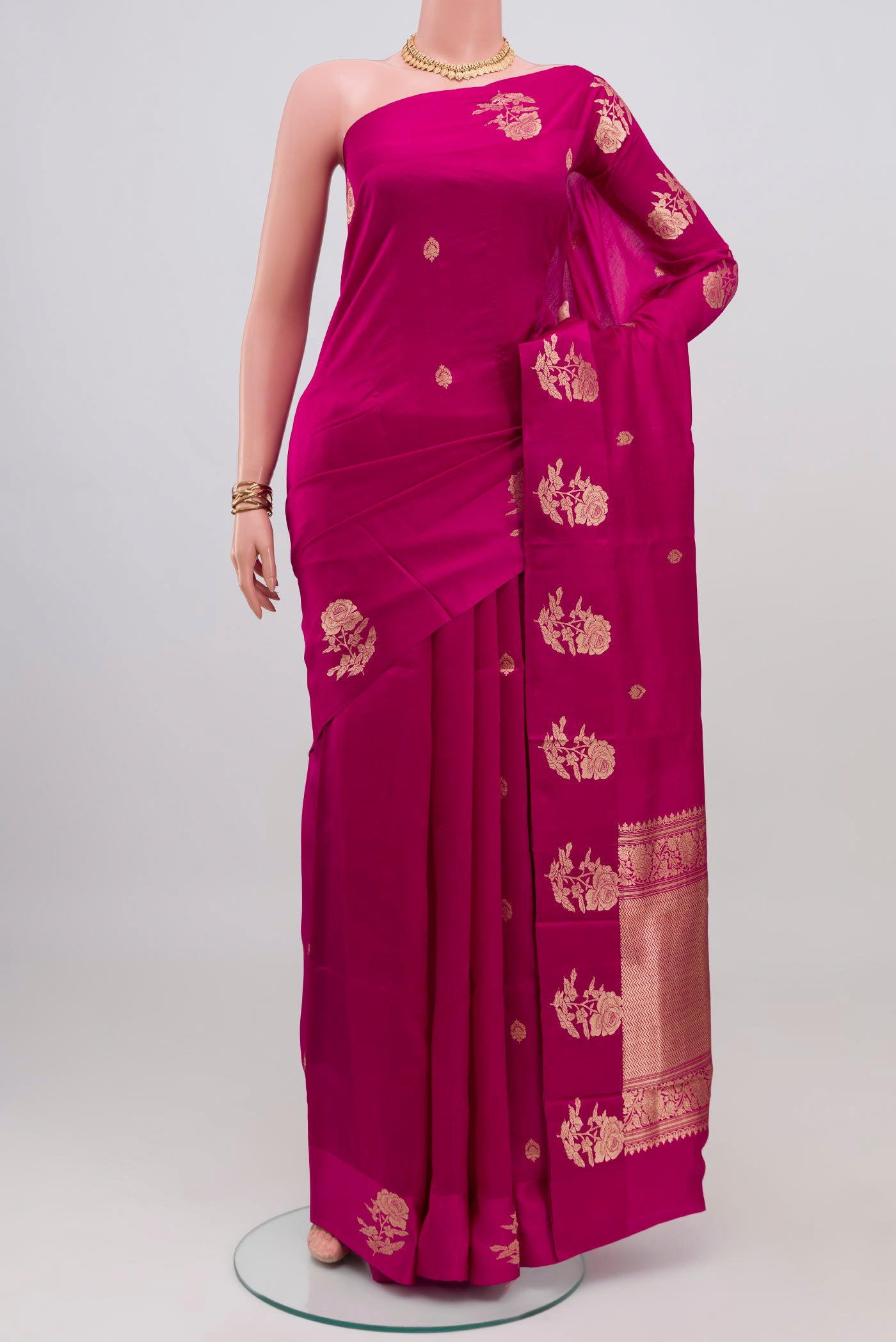 Magenta Banarasi Katan Silk Saree with Zari Butta on the body and Fancy Border.  displayed on a mannequin