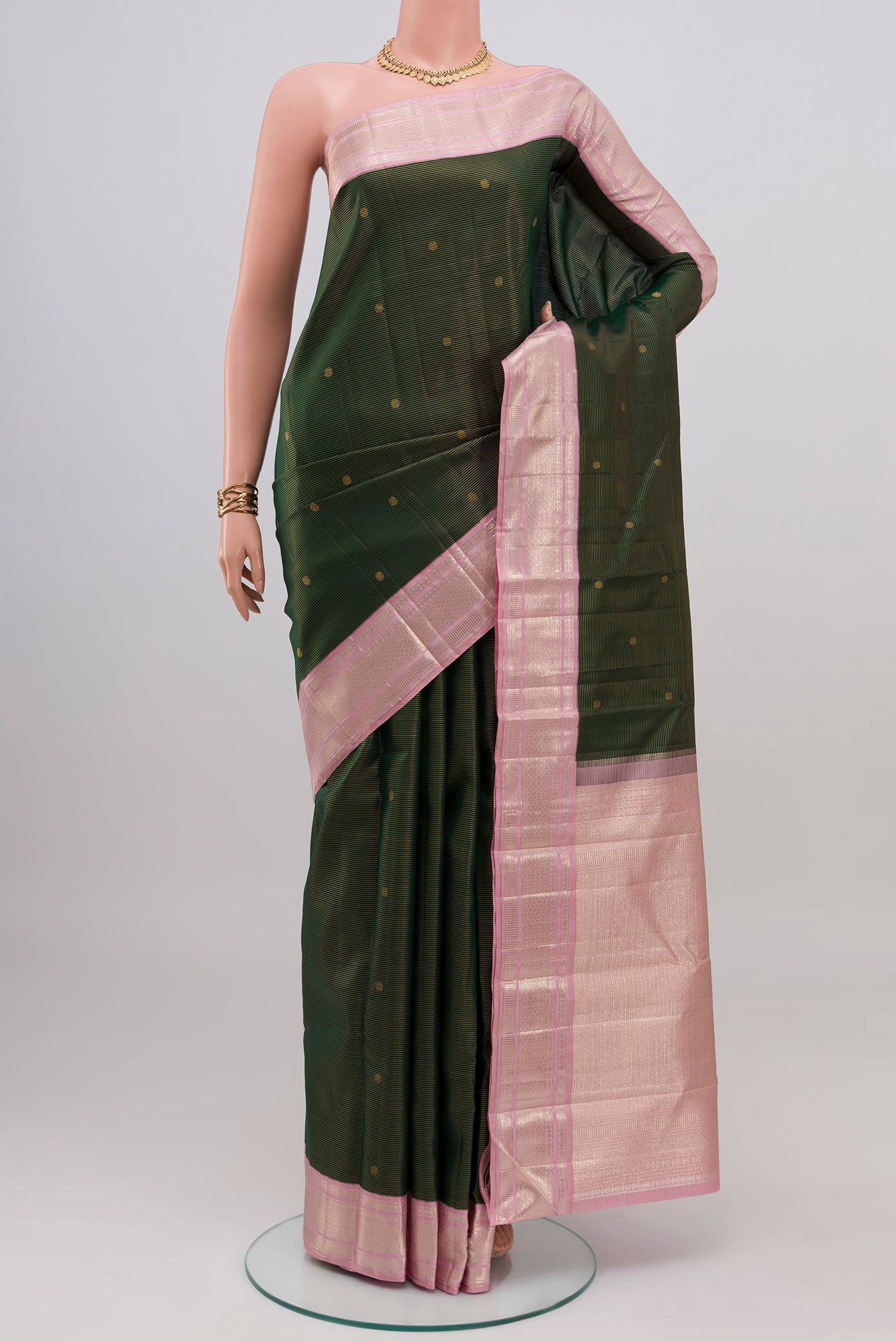 Bottle Green Kanchipuram Silk Saree with Zari Butta on the body and Zari Border.  displayed on a mannequin