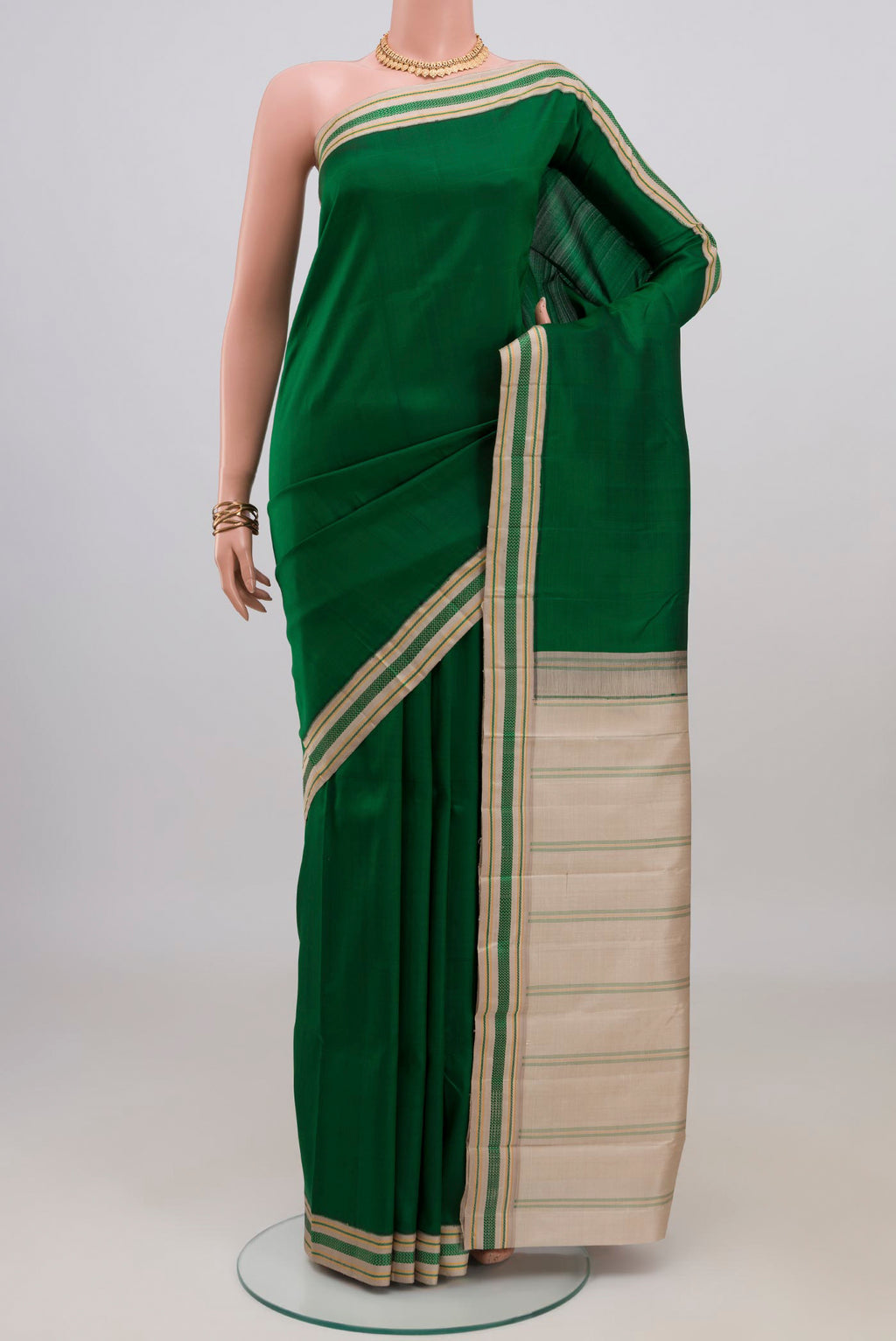 Green Kanjivaram Silk Saree with Plain Body and Thread Border.  displayed on a mannequin
