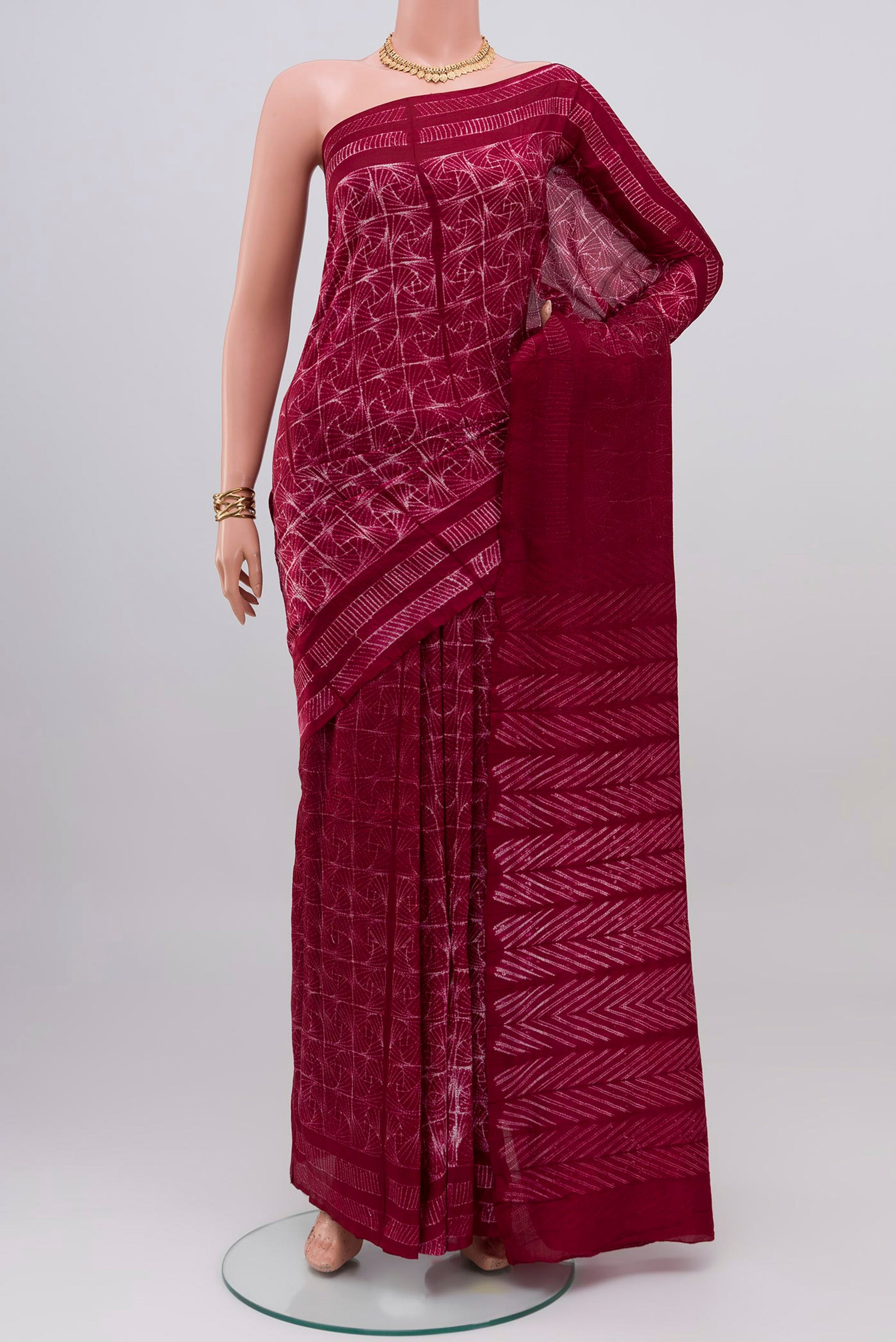 Maroon Tussar Silk Saree with Printed design on the body and Printed Border.  displayed on a mannequin