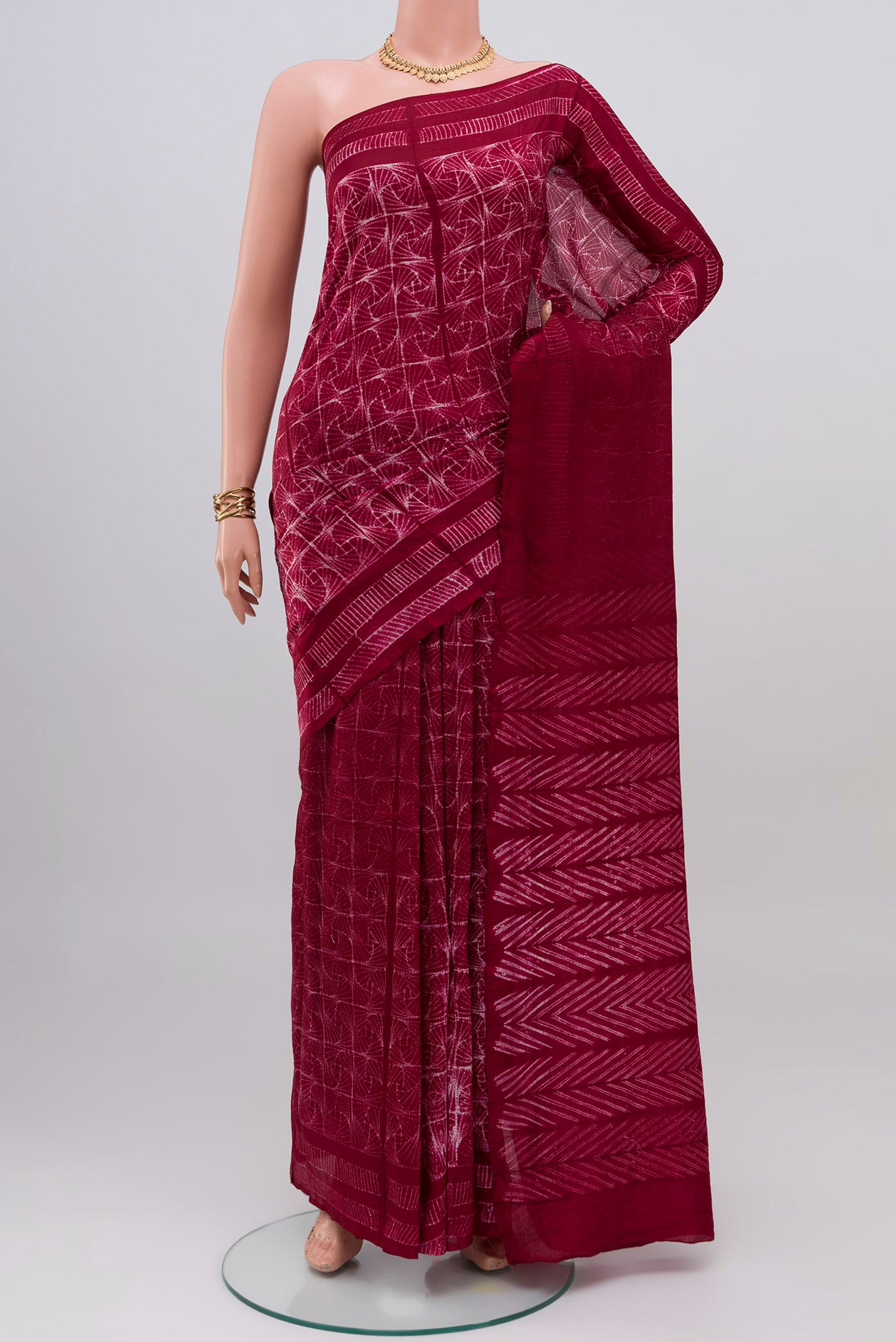 Maroon Tussar Silk Saree with Printed design on the body and Printed Border.  displayed on a mannequin