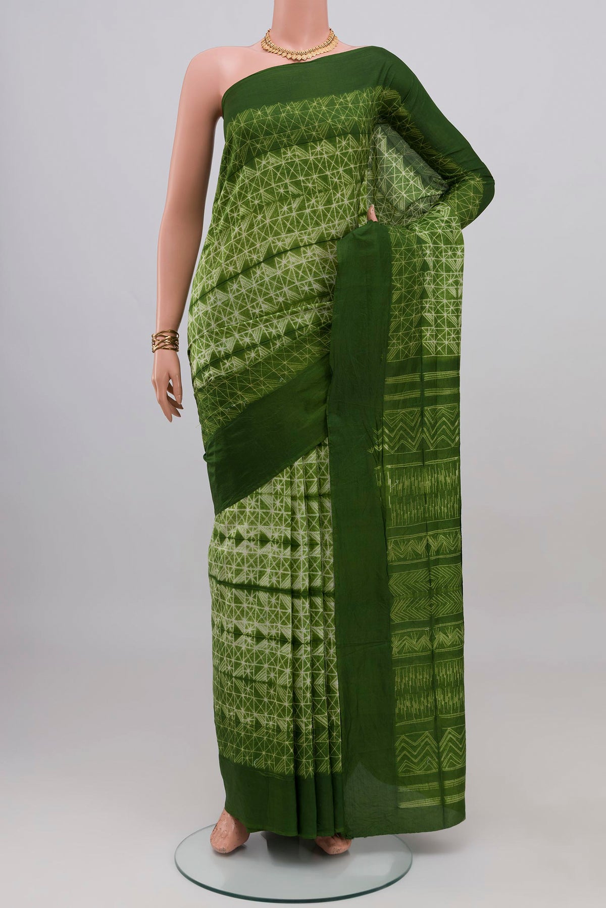 Green Tussar Silk Saree with Printed design on the body and Plain Border.  displayed on a mannequin