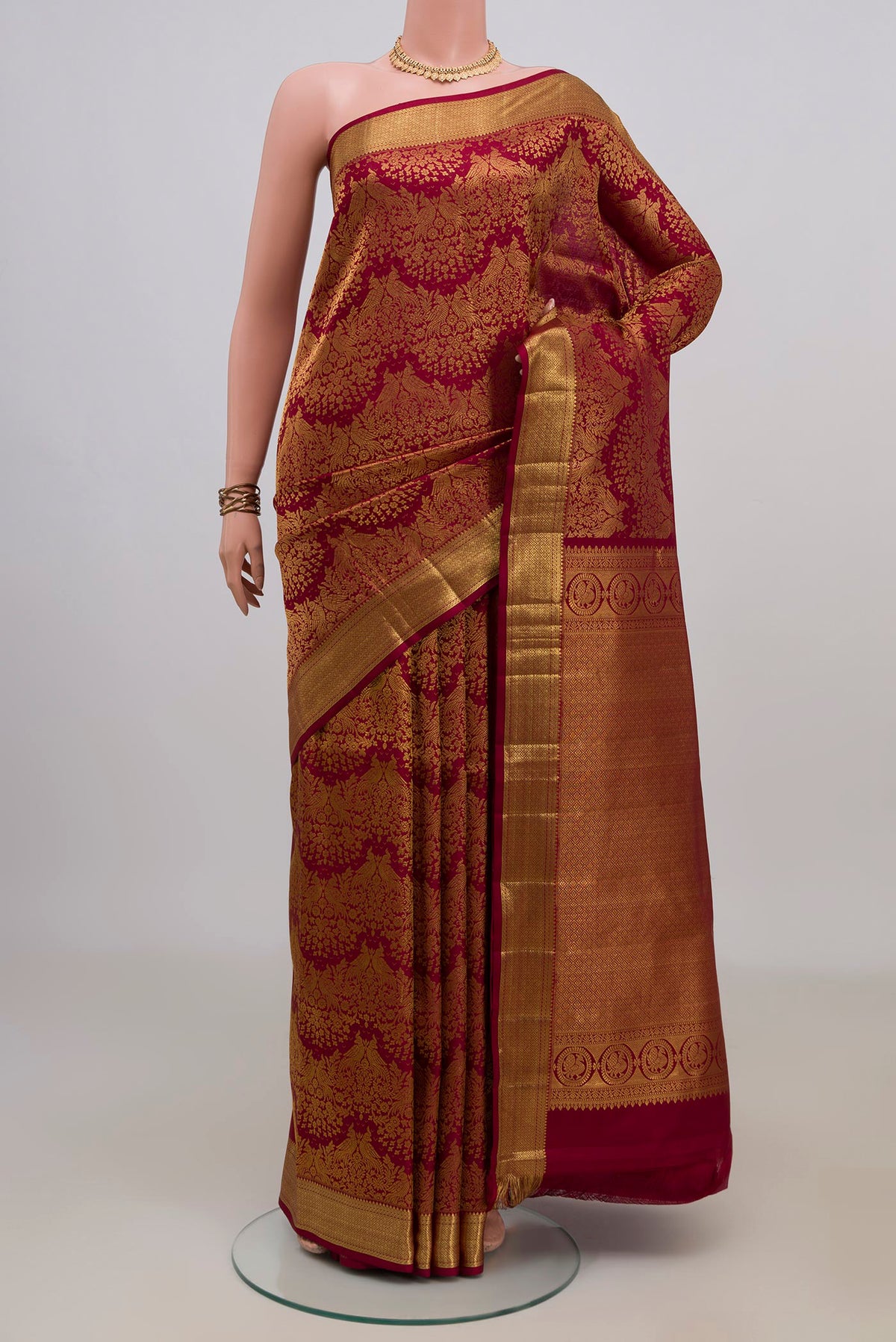 Pure Silk Maroon Kanchipuram Saree with Zari Brocade on the body and Zari Border.  displayed on a mannequin
