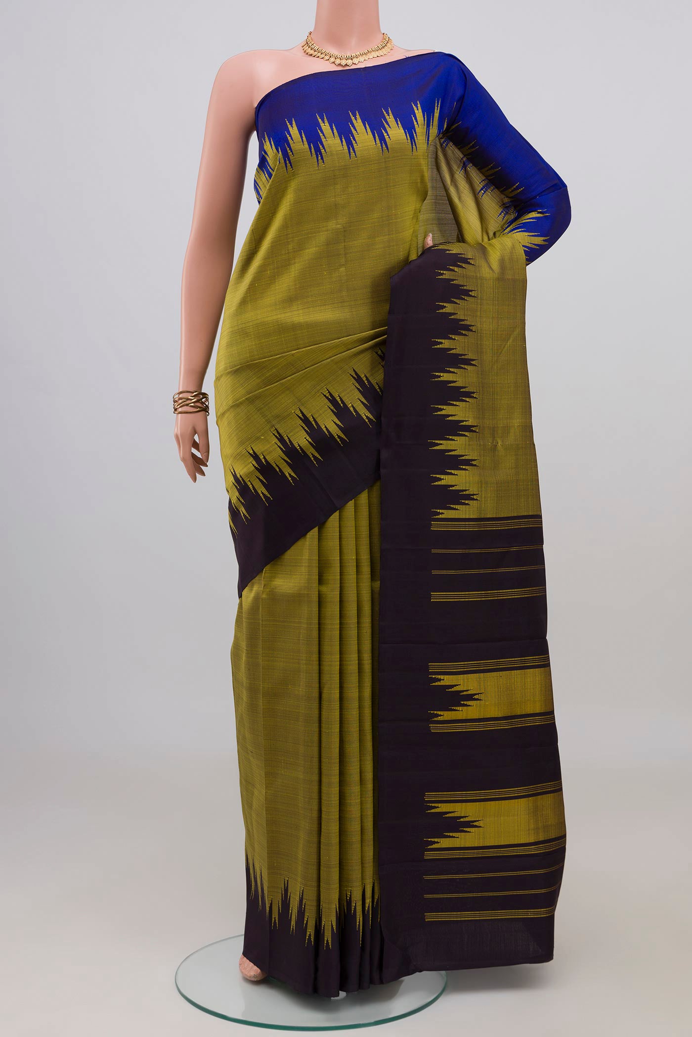 Mehandi Green Kanjivaram Silk Saree with Plain Body and Ganga Jamuna Border.  displayed on a mannequin