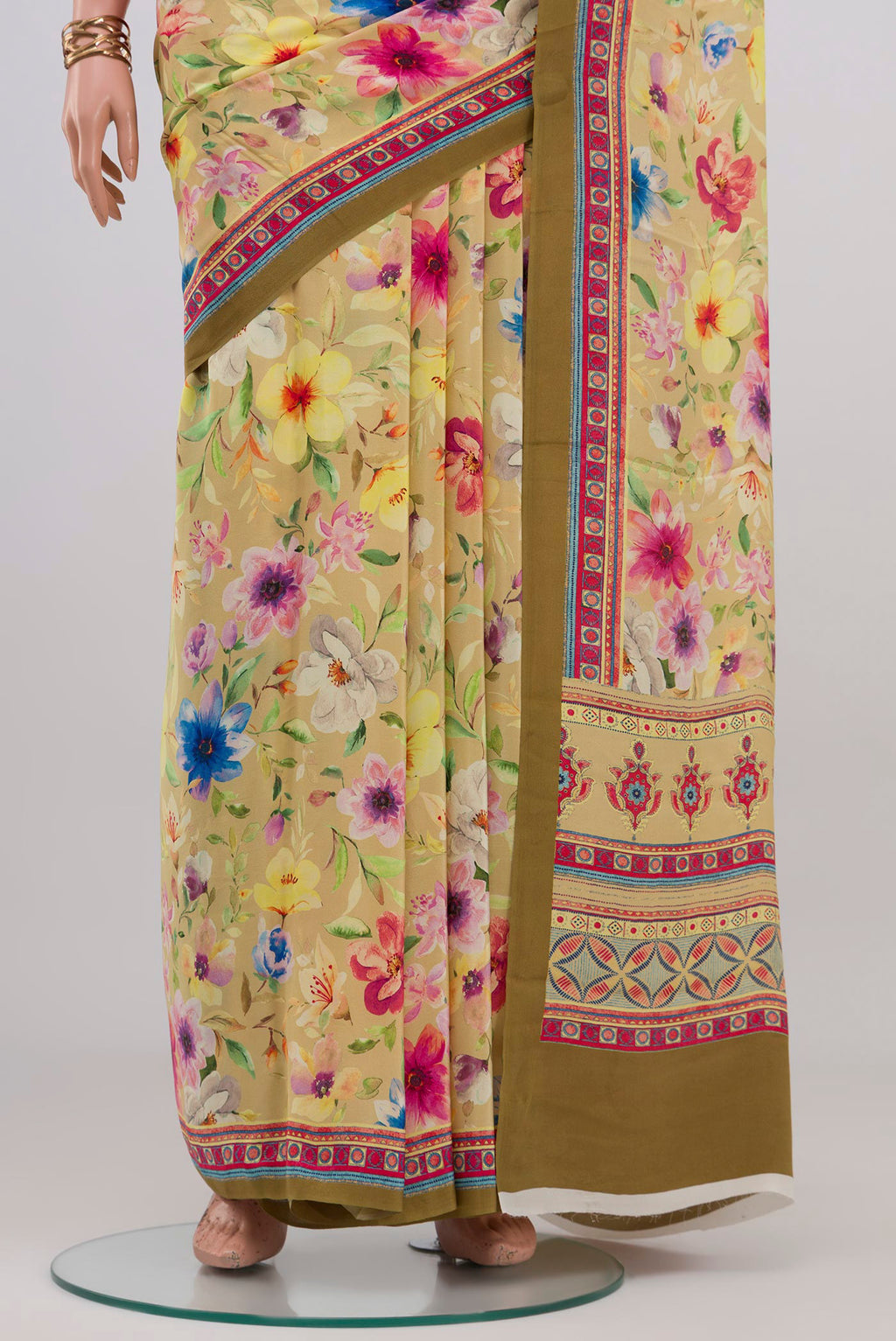 Pleats and pallu of Beige Crepe Saree with Printed design on the body and Printed Border. 