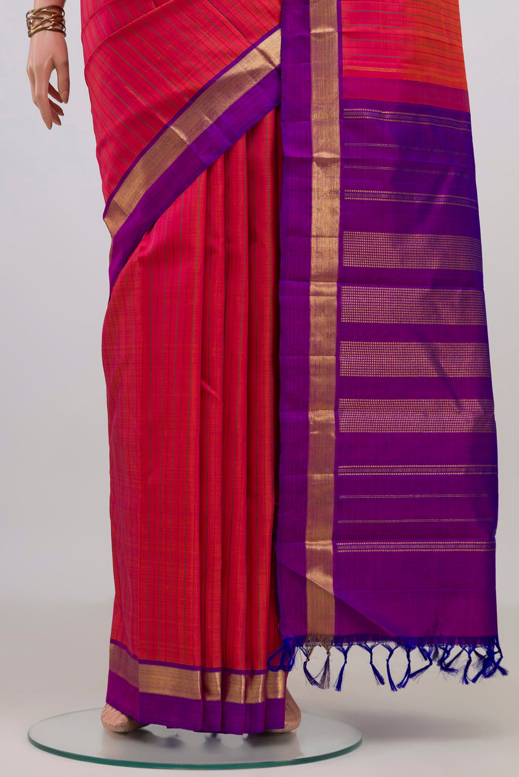 Pleats and pallu of Pure Silk Brick Orange Kanchipuram Saree with Thread Butta on the body and Zari Border. 