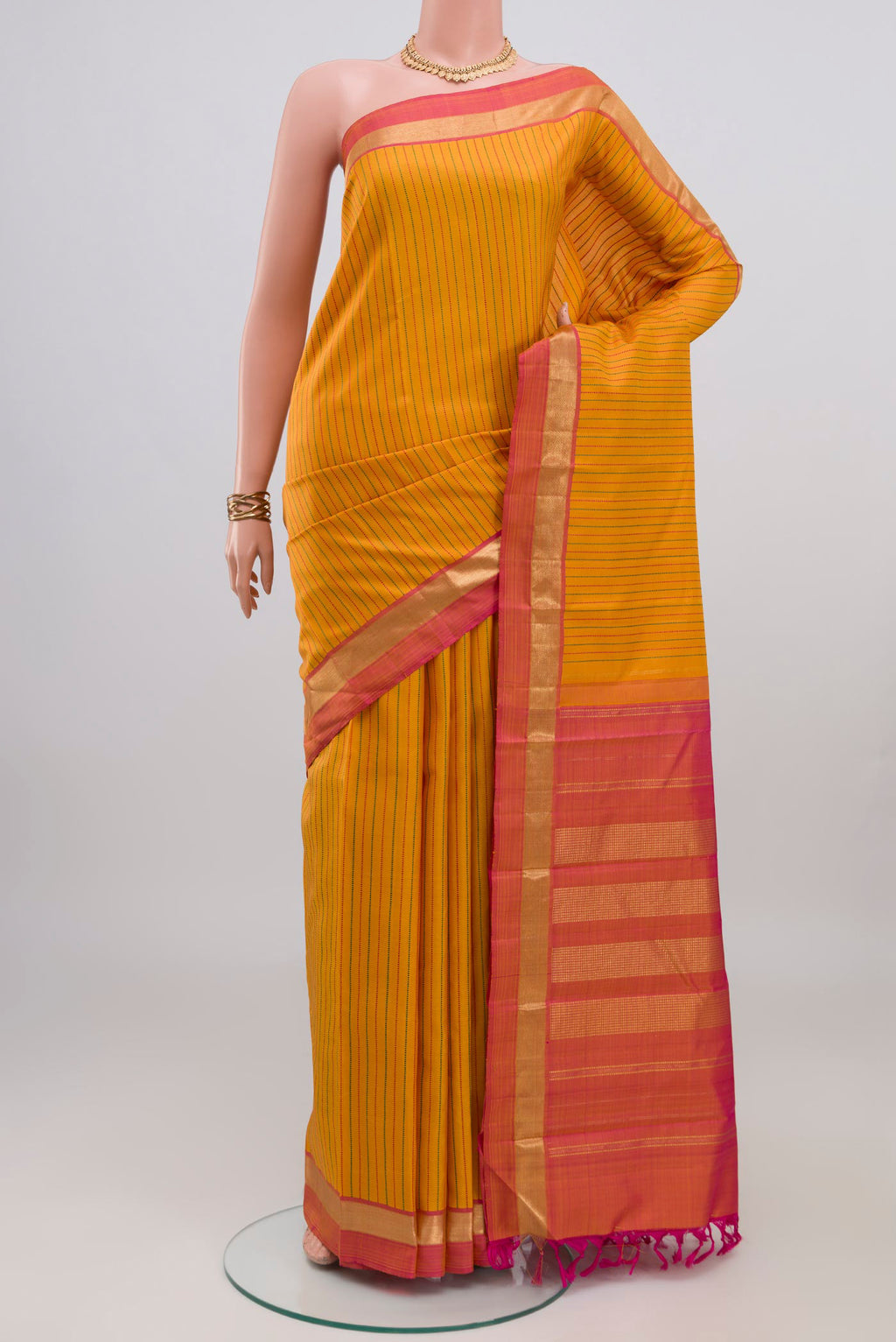 Yellow Kanchipuram Silk Saree with Stripes on the body and Zari Border.  displayed on a mannequin