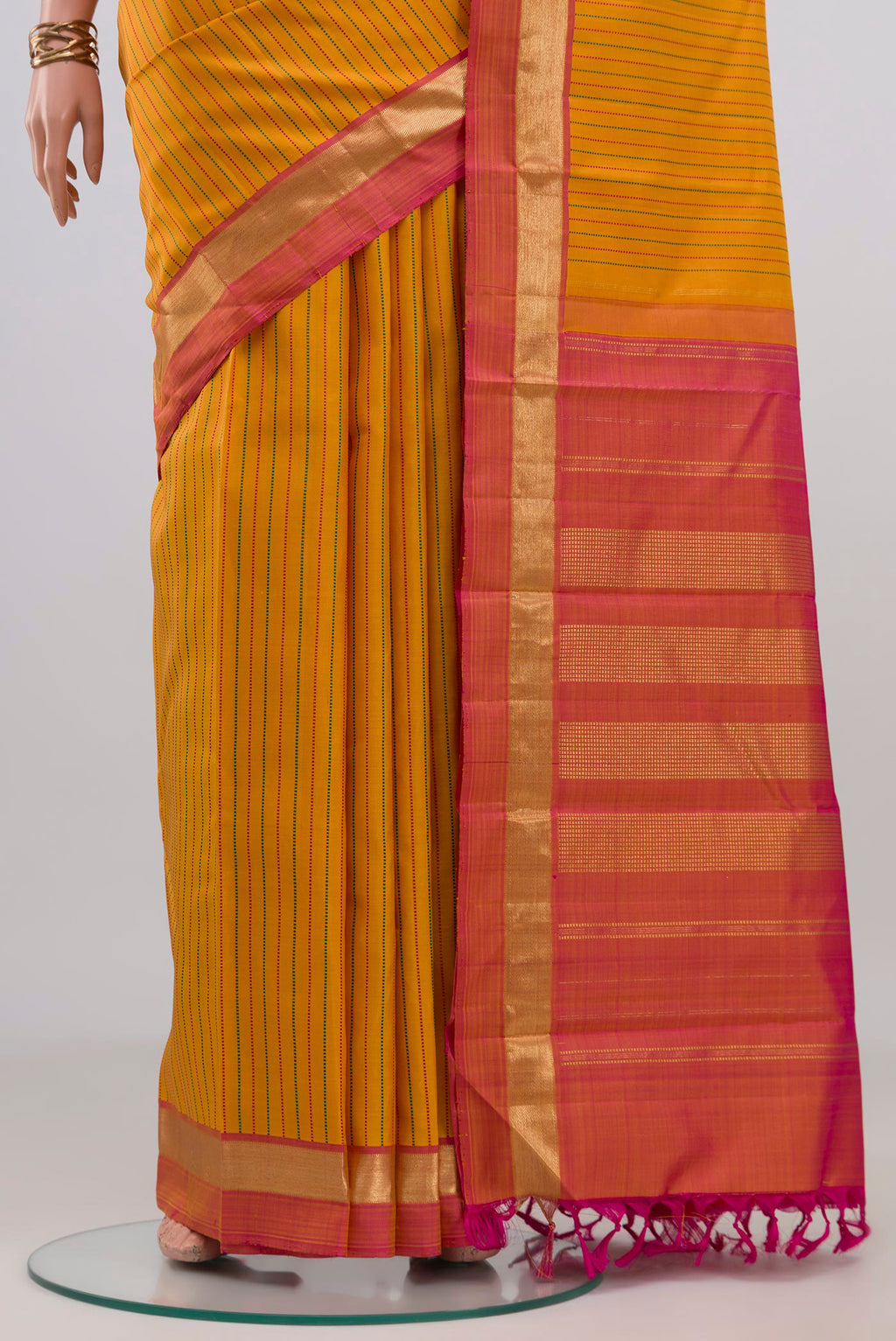 Pleats and pallu of Yellow Kanchipuram Silk Saree with Stripes on the body and Zari Border. 