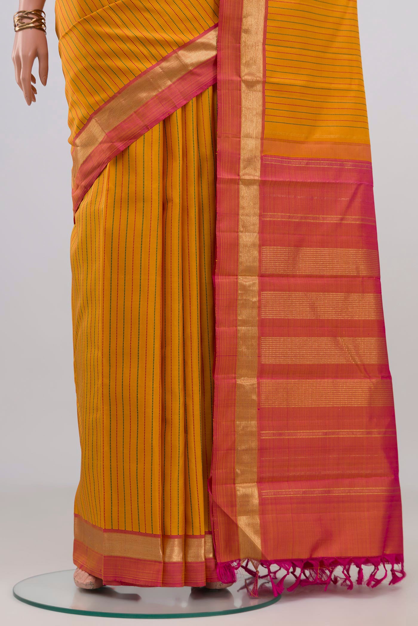 Pleats and pallu of Yellow Kanchipuram Silk Saree with Stripes on the body and Zari Border. 