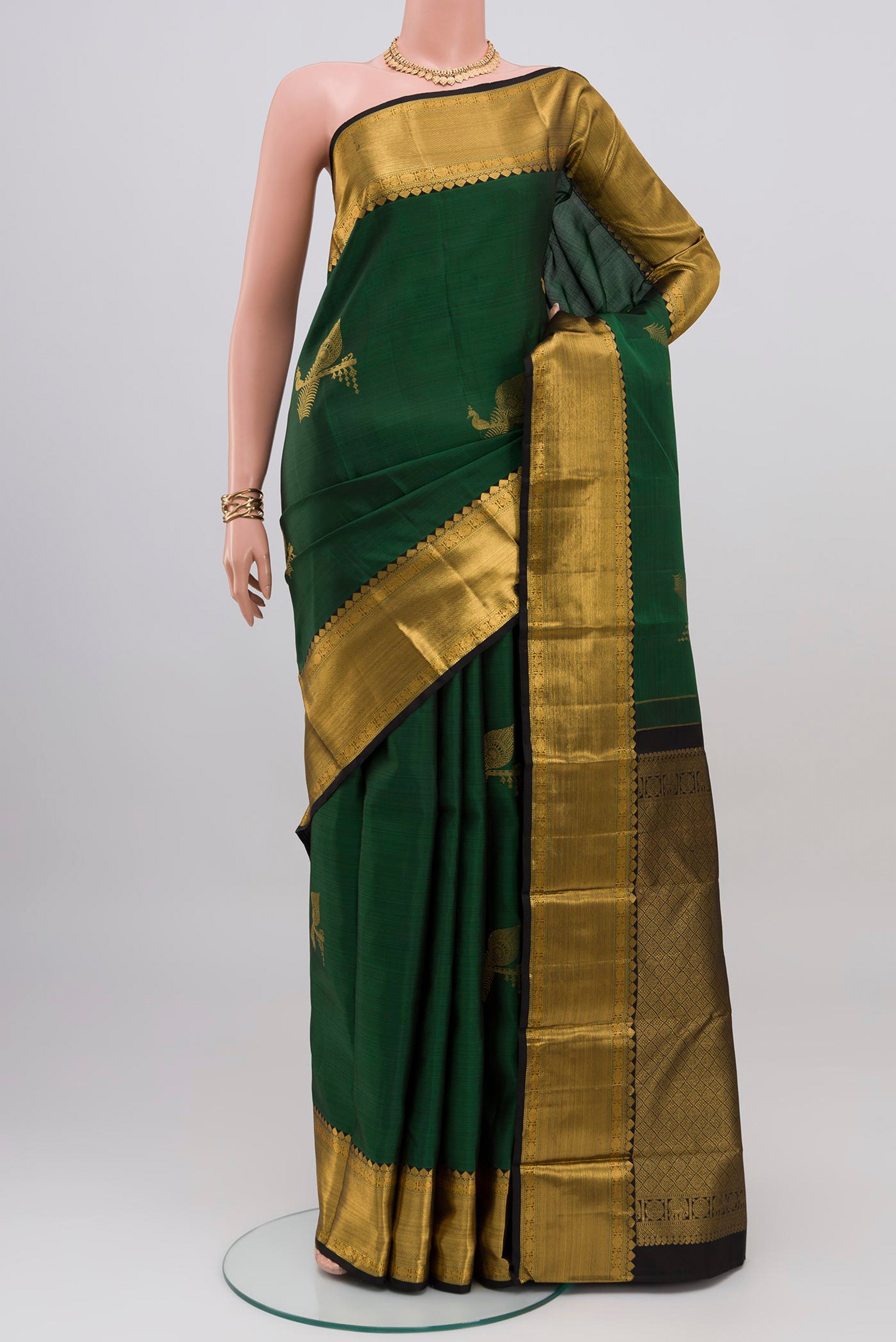 Bottle Green Kanjivaram Silk Saree with Zari Butta on the body and Zari Border.  displayed on a mannequin