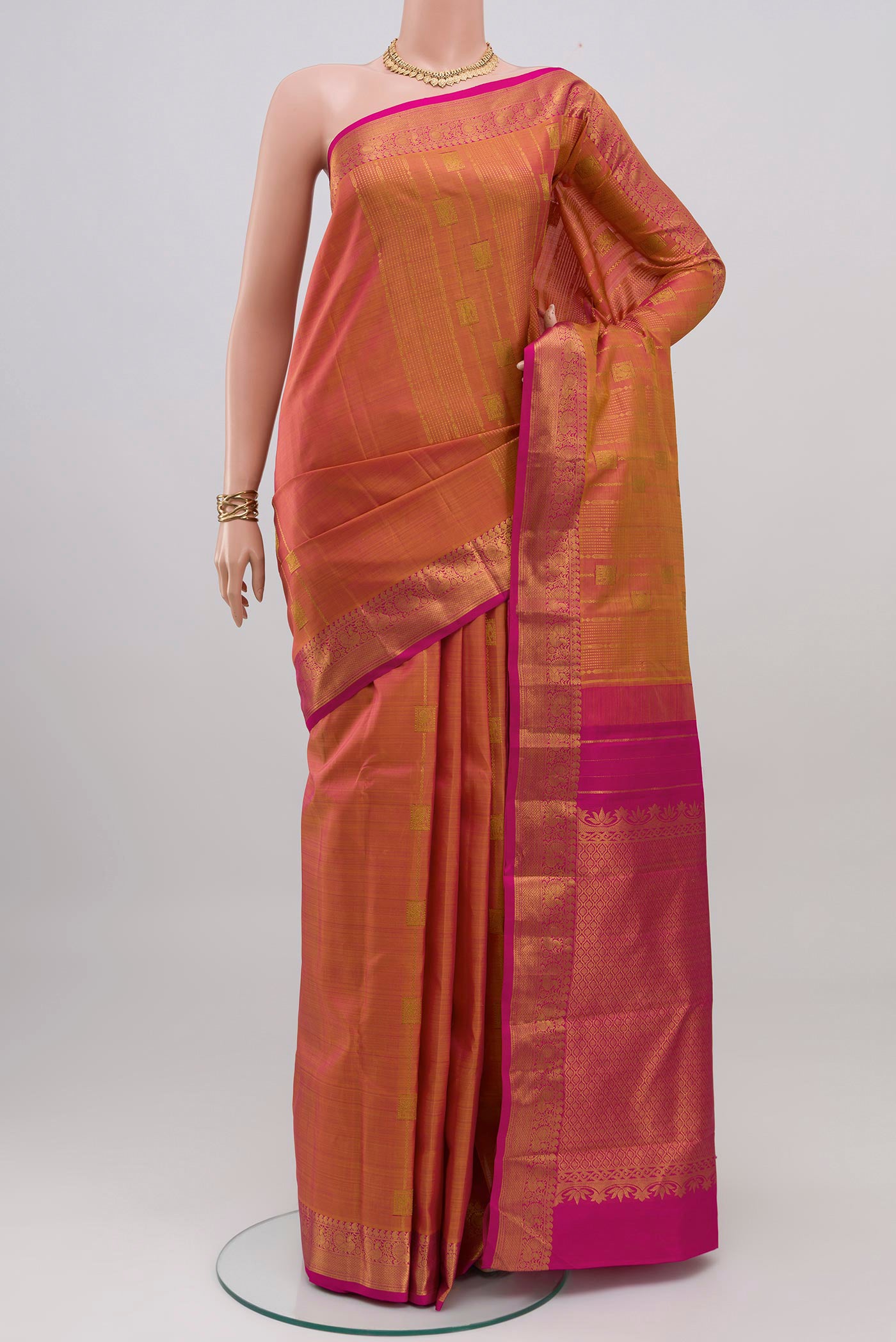 Pinkish Yellow Dual Tone Kanjivaram Silk Saree with Stripes on the body and Zari Border.  displayed on a mannequin