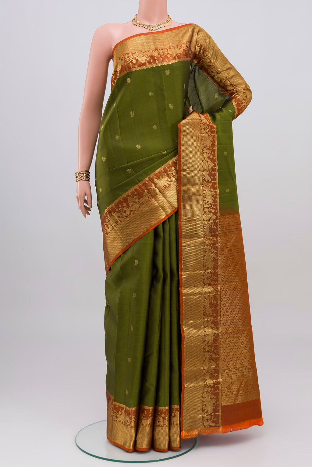 Mehandi Green Kanchipuram Silk Saree with Zari Butta on the body and Zari Border.  displayed on a mannequin