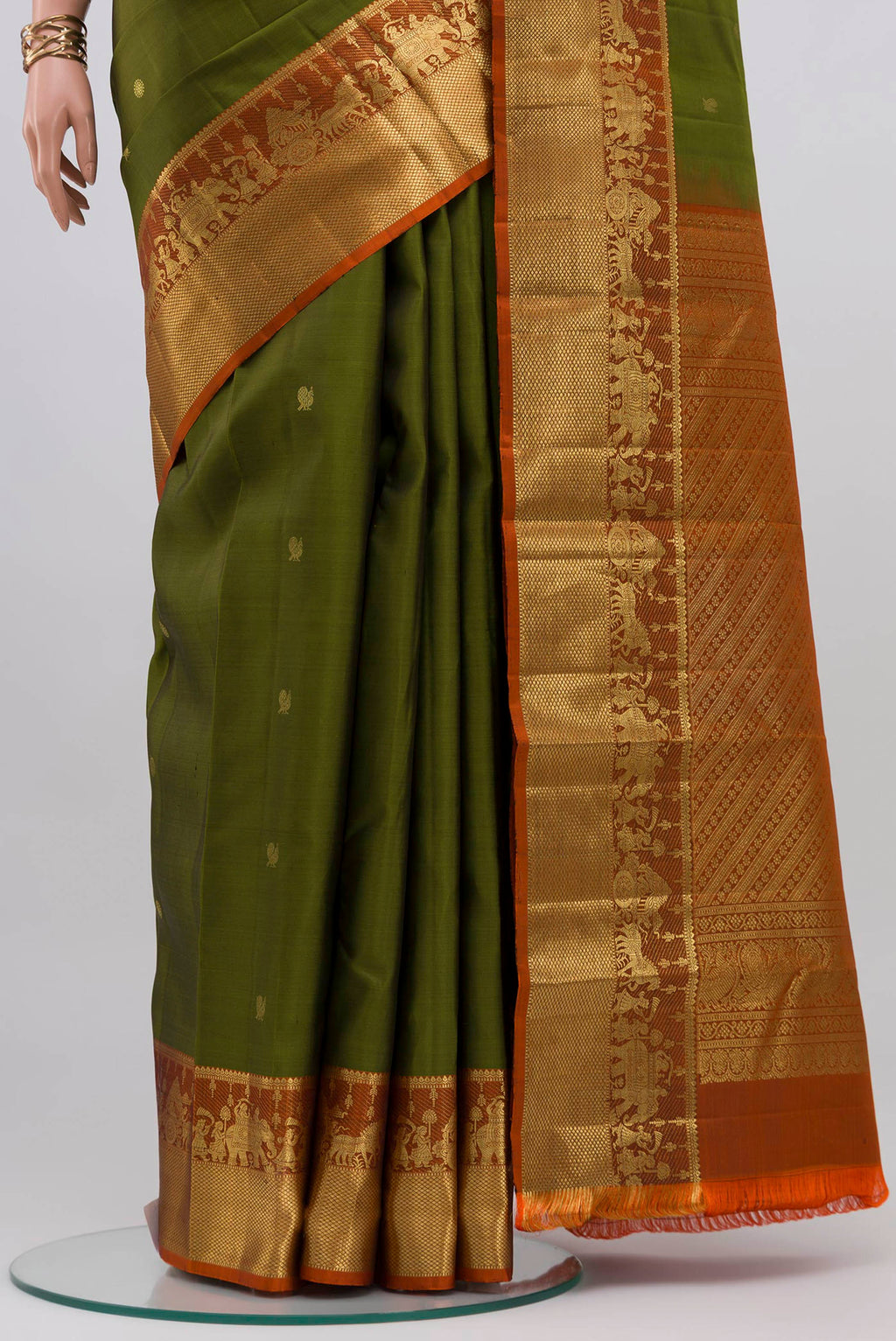 Pleats and pallu of Mehandi Green Kanchipuram Silk Saree with Zari Butta on the body and Zari Border. 