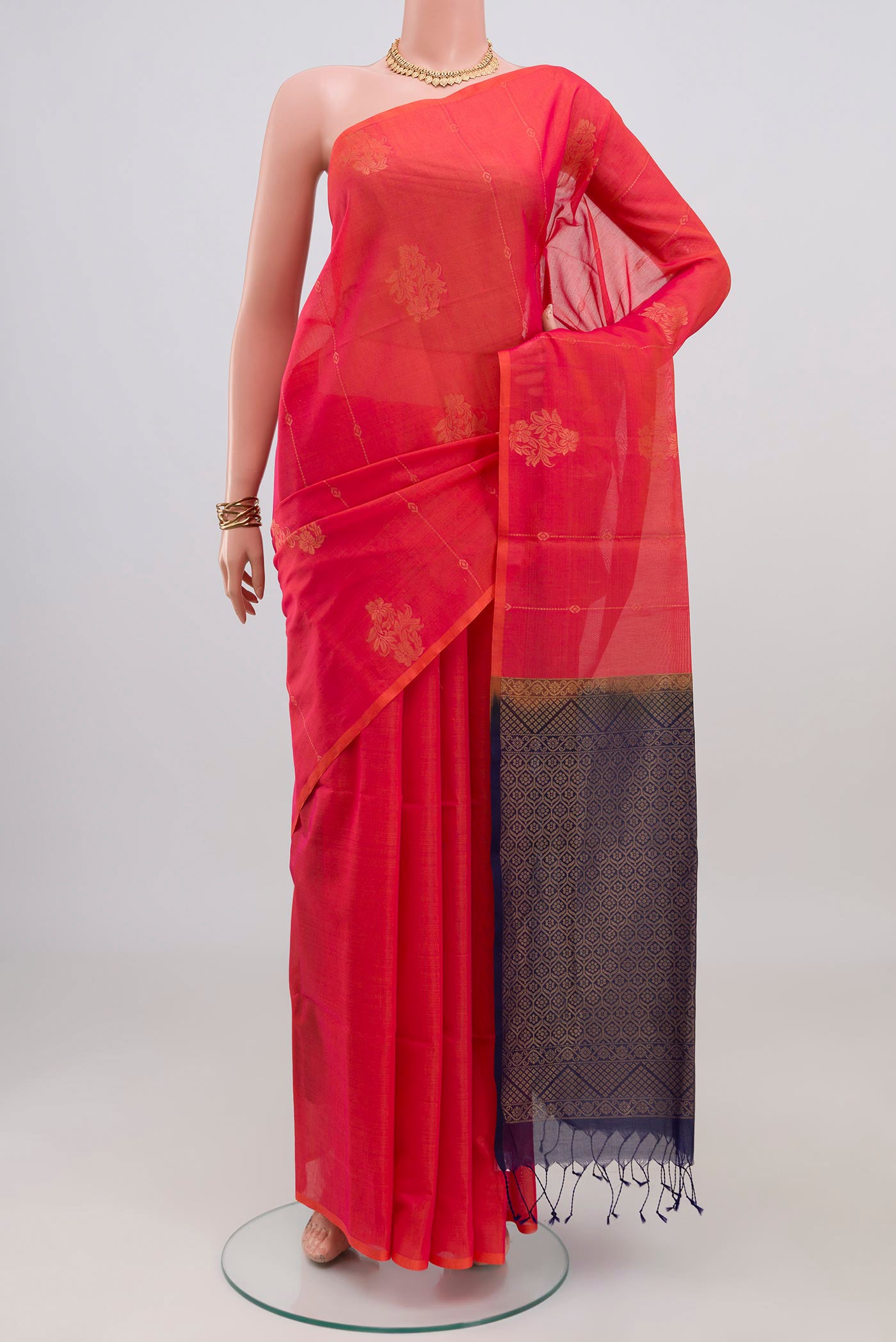 Coral Silk Cotton Saree with Zari Butta on the body and Without Border.  displayed on a mannequin