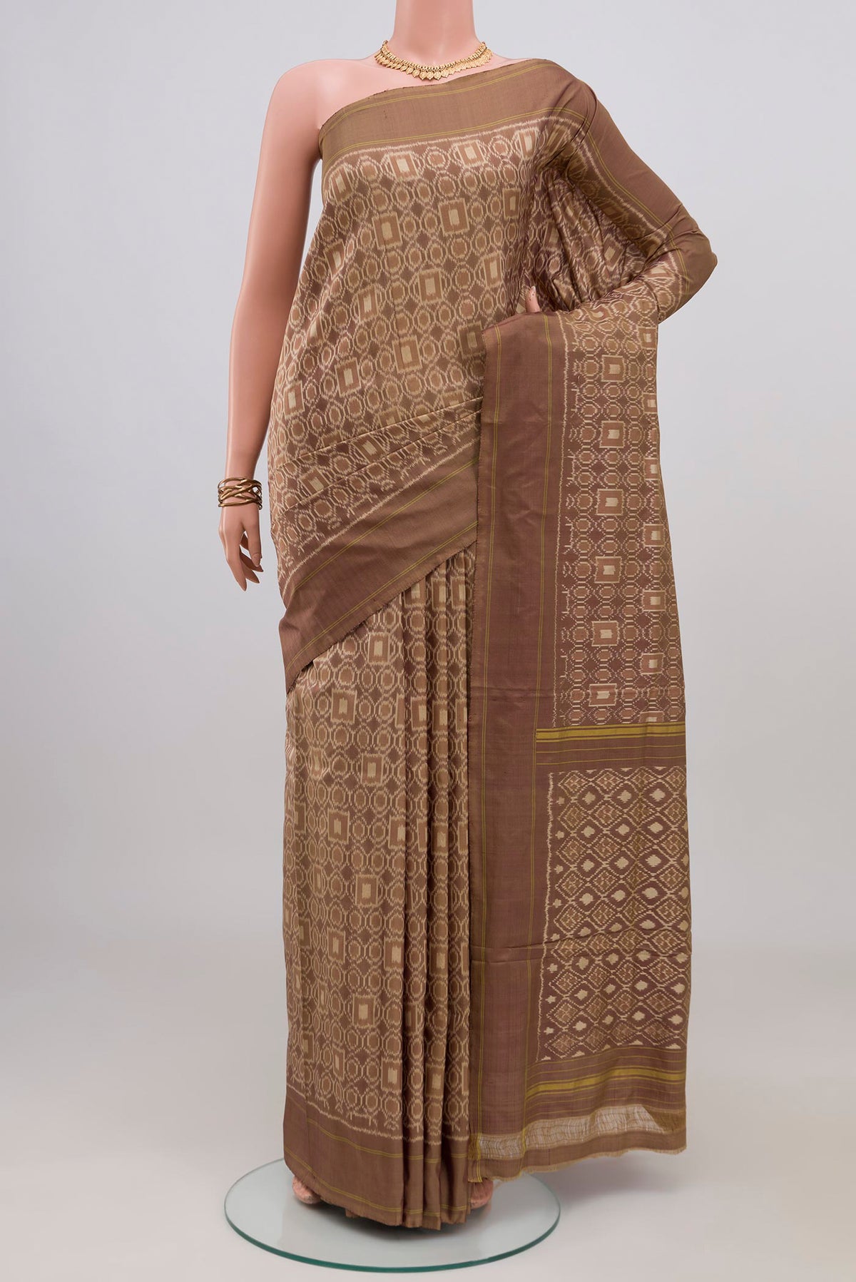 Brown Pochampally Silk Saree with Ikat design on the body and Plain Border.  displayed on a mannequin