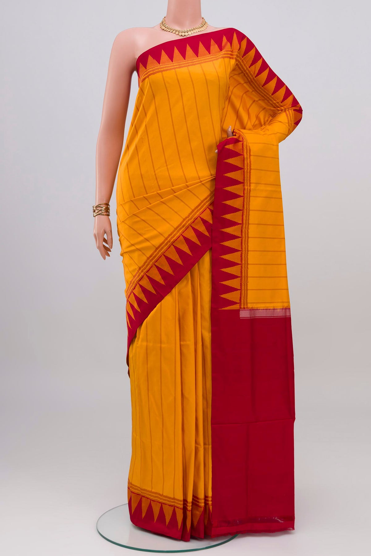Yellow Pochampally Silk Saree with Ikat design on the body and Temple Border.  displayed on a mannequin