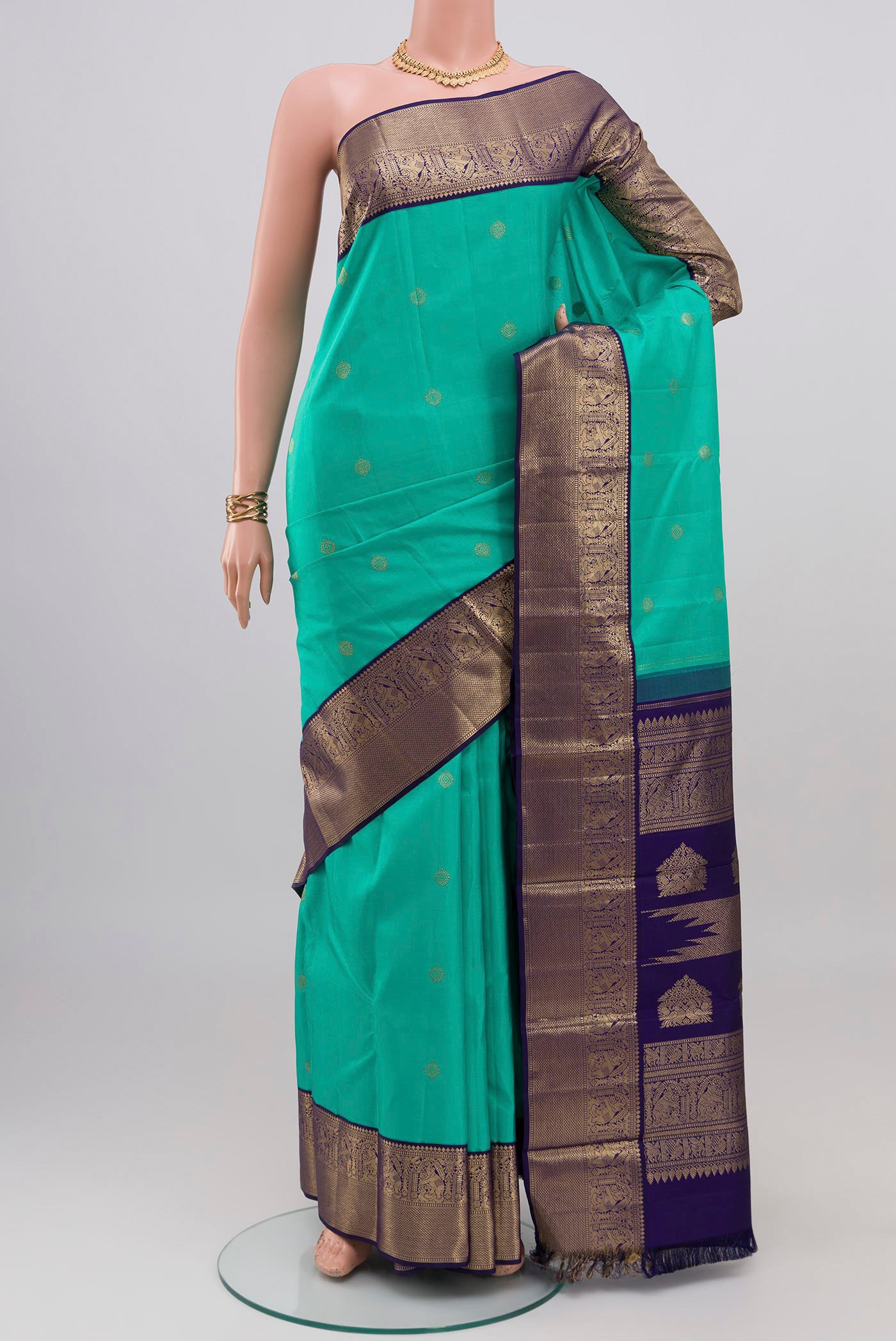 Turquoise Kanjivaram Silk Saree with Zari Butta on the body and Zari Border.  displayed on a mannequin