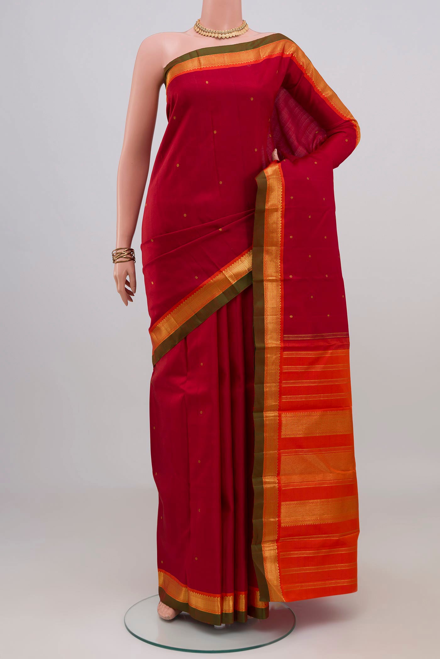 Maroon Kanchipuram Silk Saree with Zari Butta on the body and Zari Border.  displayed on a mannequin