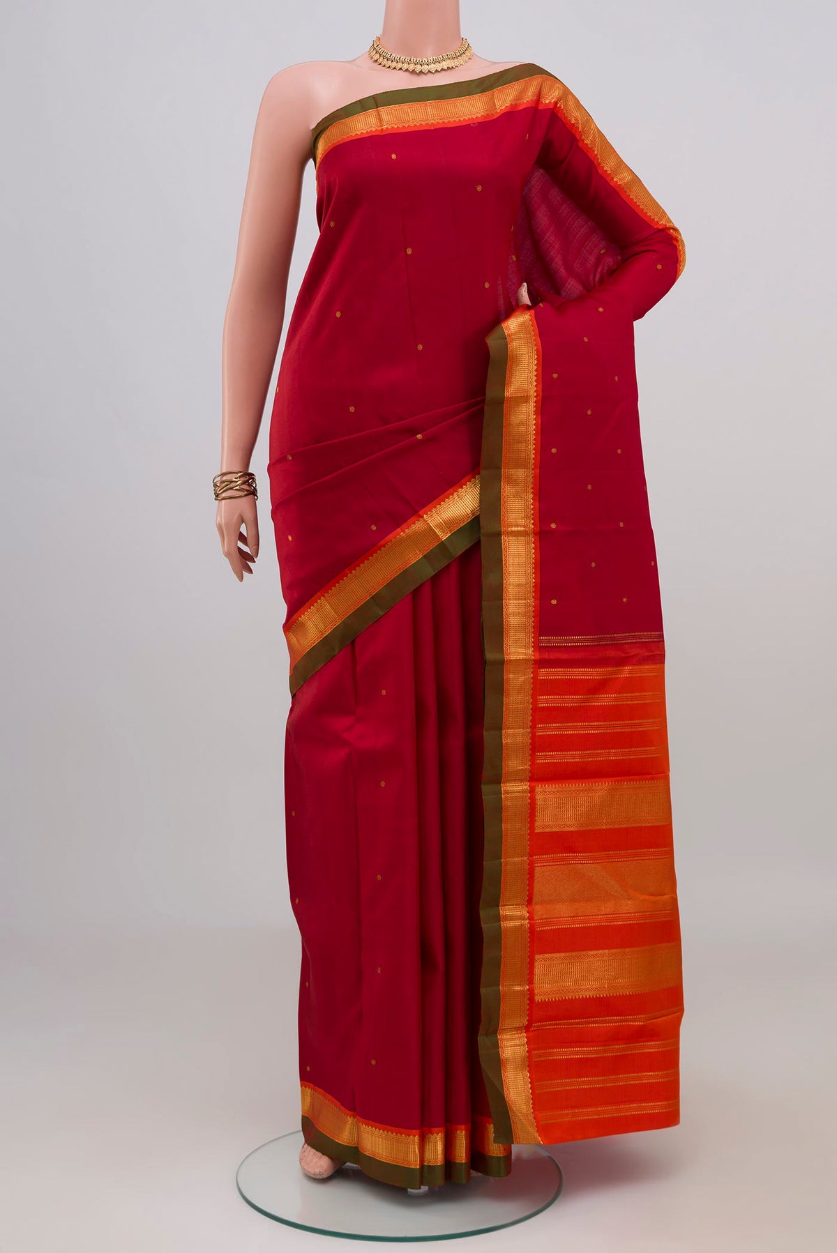 Maroon Kanchipuram Silk Saree with Zari Butta on the body and Zari Border.  displayed on a mannequin