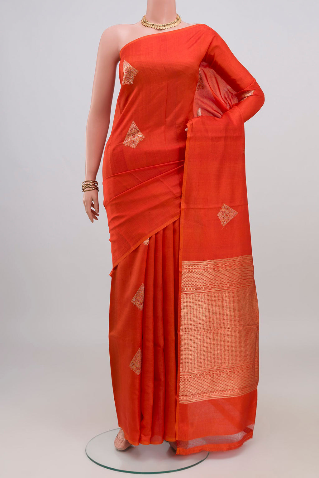 Orange Banarasi Katan Silk Saree with Zari Butta on the body and Without Border.  displayed on a mannequin