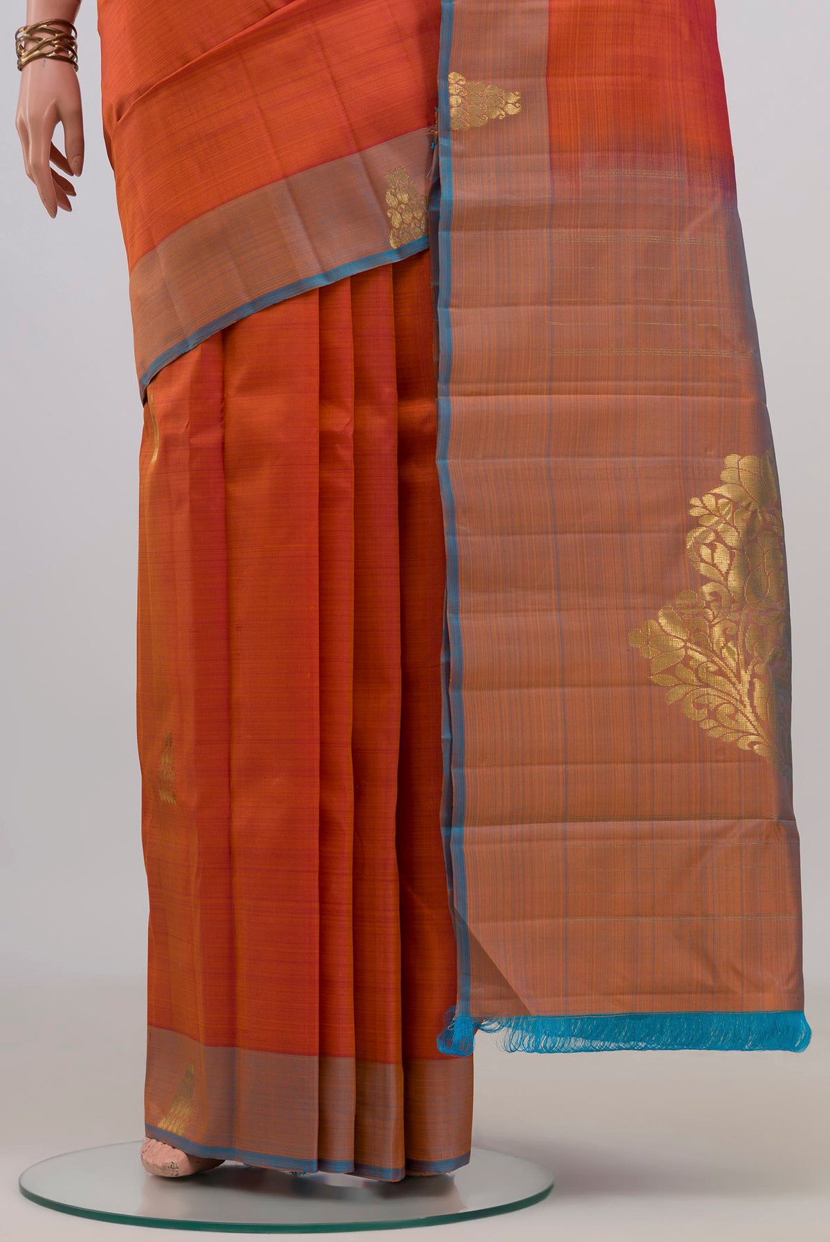 Pleats and pallu of Pure Silk Orange Kanchipuram Saree with Zari Butta on the body and Fancy Border. 