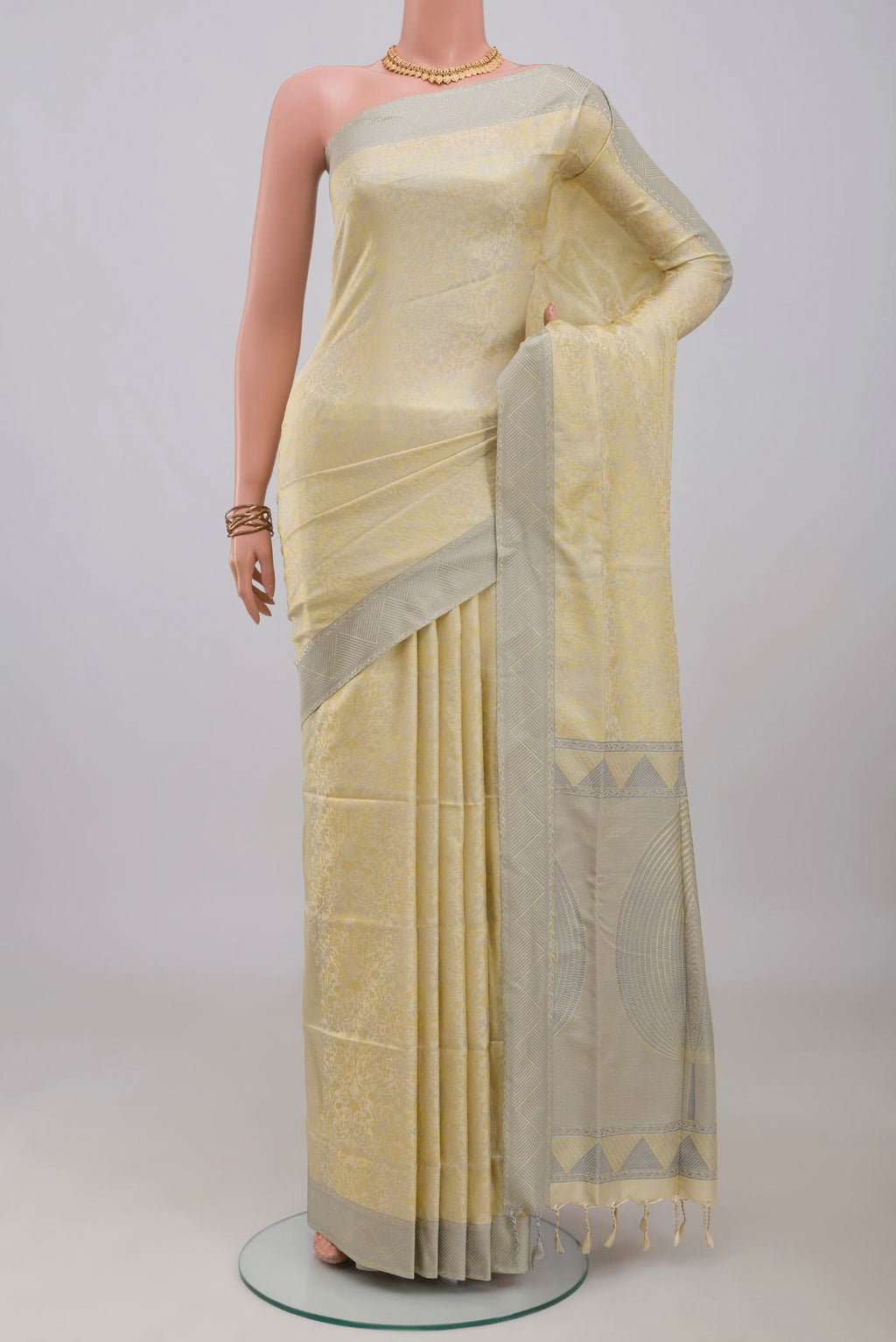 Cream Soft Silk Saree with Jacquard design on the body and Thread Border.  displayed on a mannequin