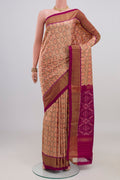 Peach Pochampally Silk Saree with Ikat design on the body and Zari Border.  displayed on a mannequin