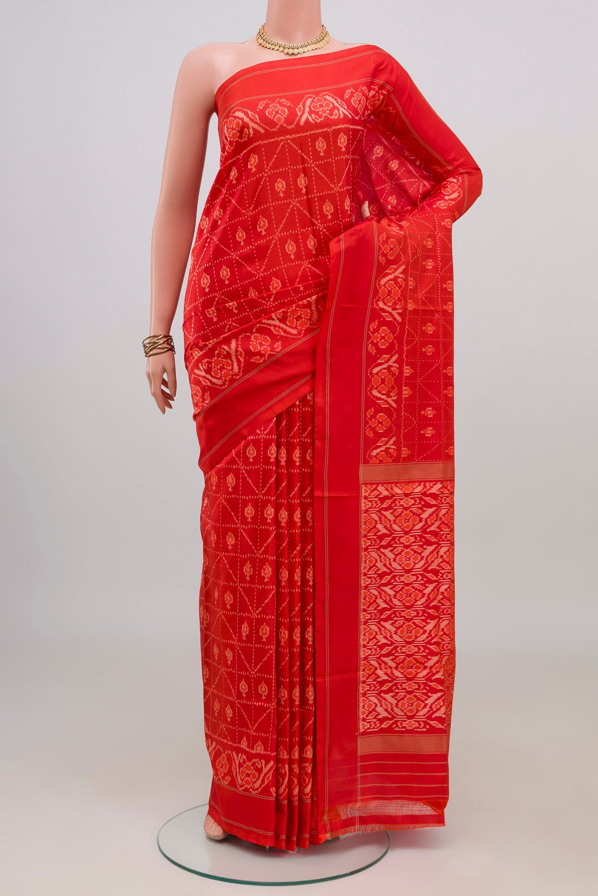 Orange Pochampally Silk Saree with Ikat design on the body and Plain Border.  displayed on a mannequin