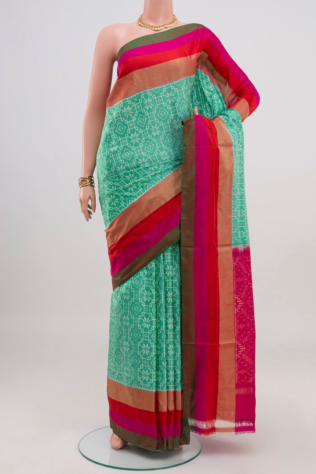 Green Pochampally Saree with Ikat design on the body and Zari Border.  displayed on a mannequin
