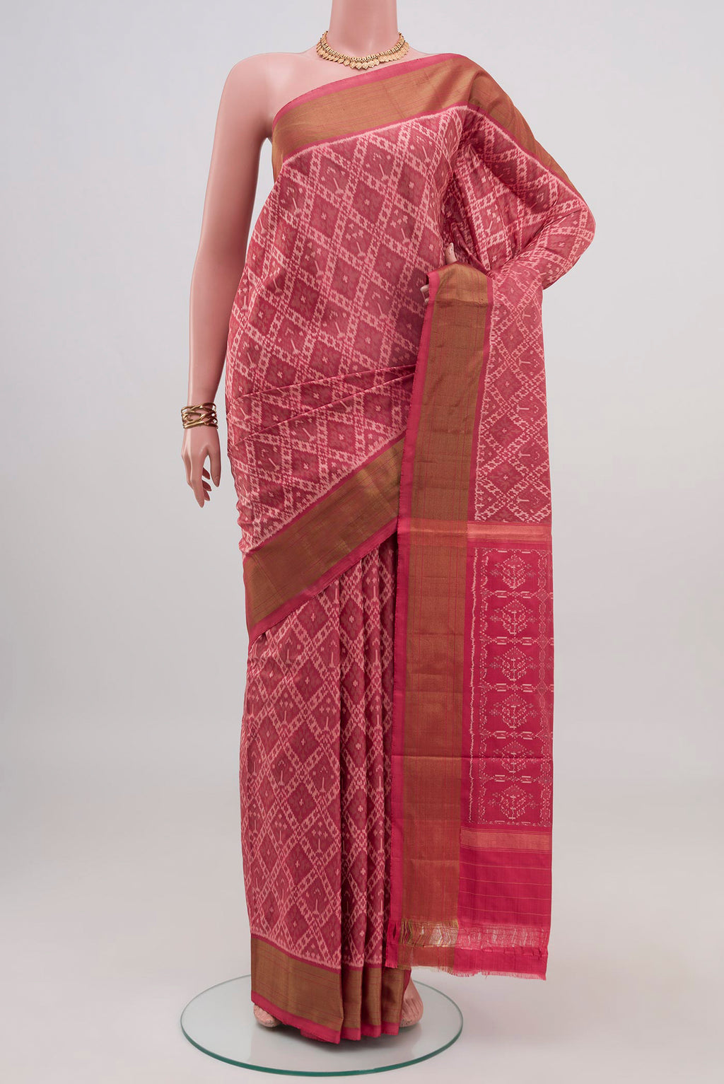 Peach Pochampally Saree with Ikat design on the body and Zari Border.  displayed on a mannequin