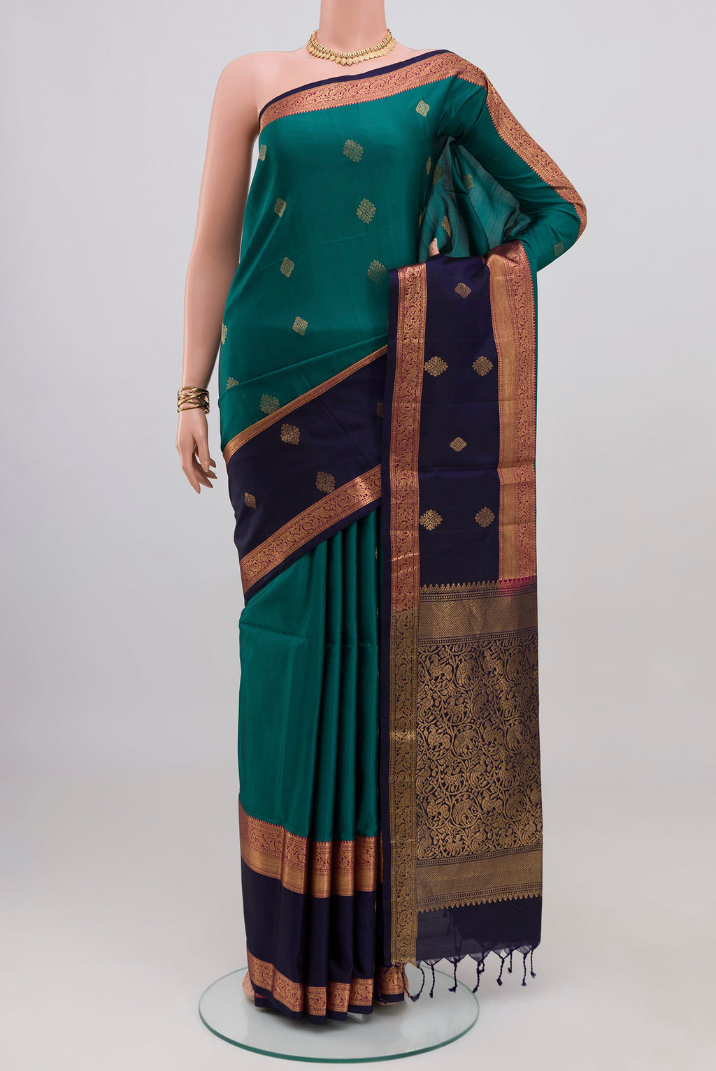 Teal Soft Silk Saree with Zari Butta on the body and Fancy Border.  displayed on a mannequin