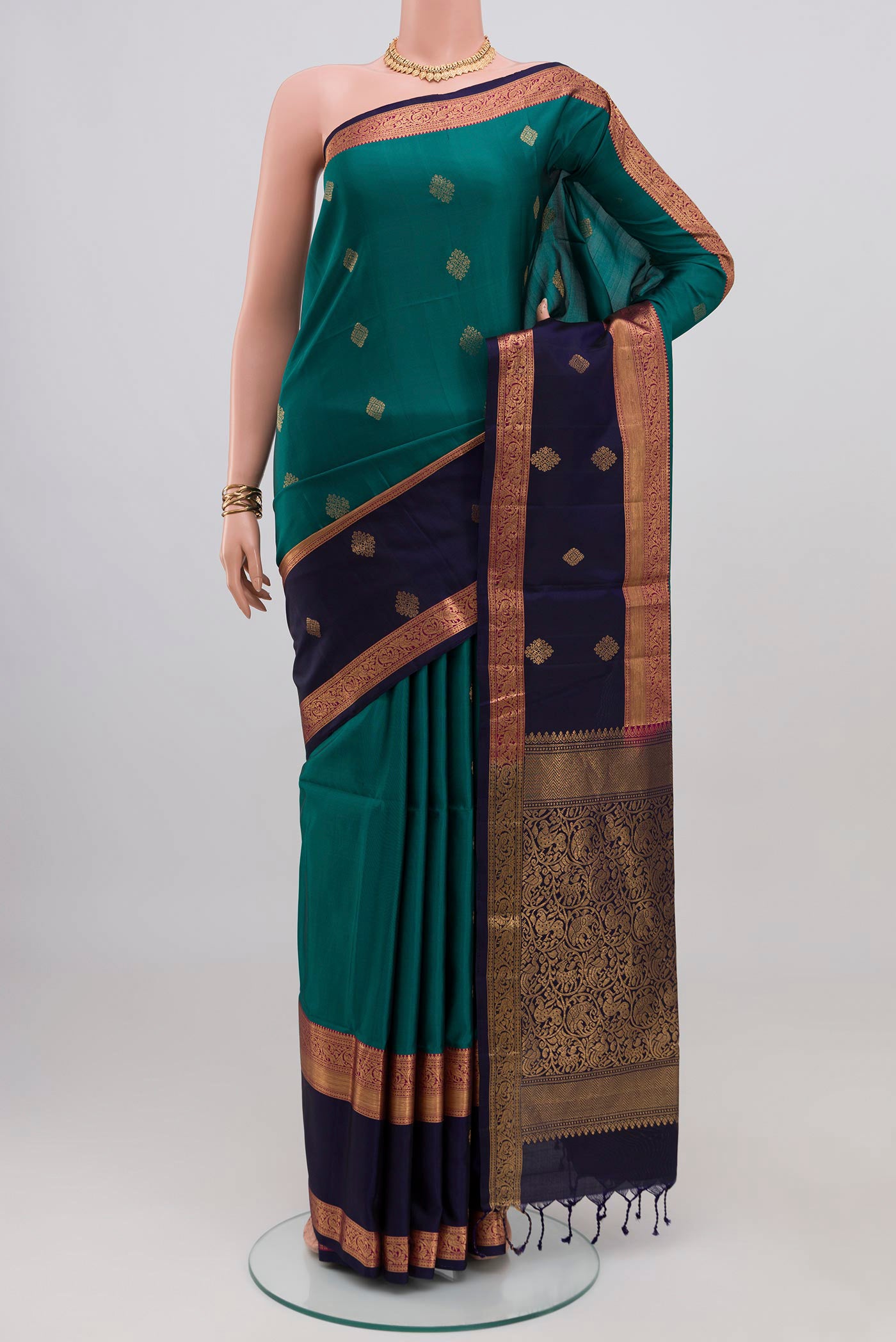 Teal Soft Silk Saree with Zari Butta on the body and Fancy Border.  displayed on a mannequin