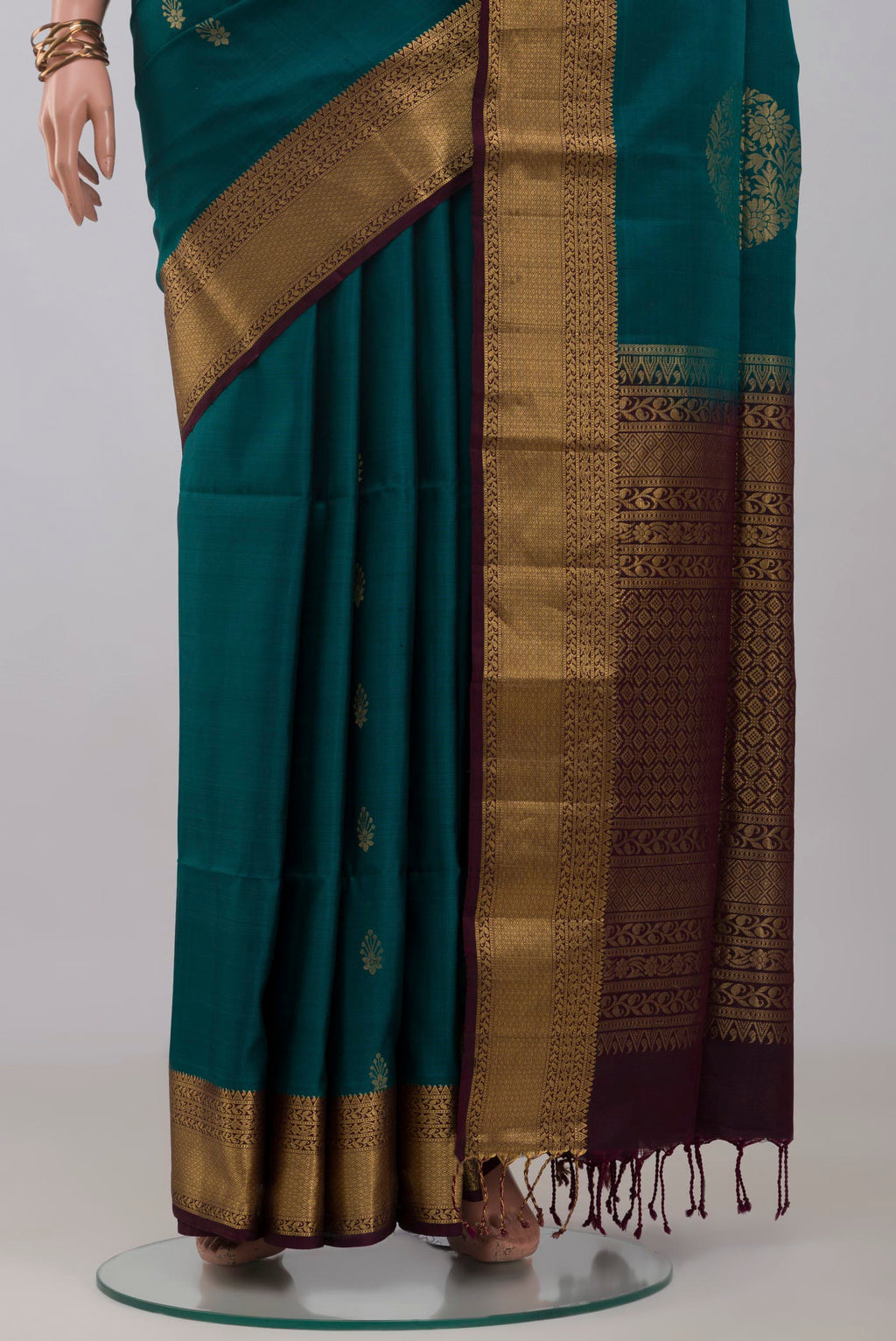 Pleats and pallu of Peacock Blue Soft Silk Saree with Zari Butta on the body and Zari Border. 