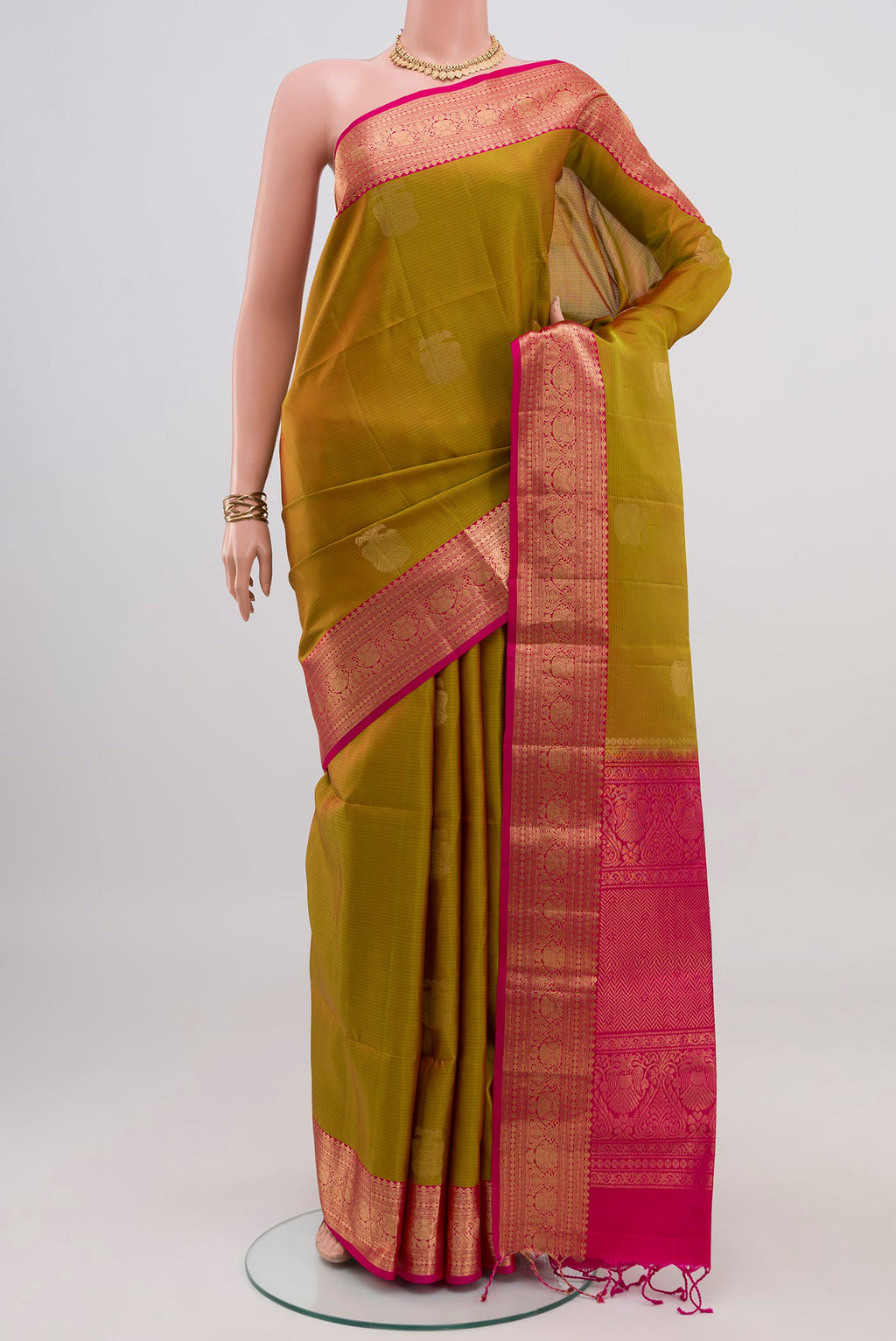 Green Soft Silk Saree with Zari Butta on the body and Zari Border.  displayed on a mannequin