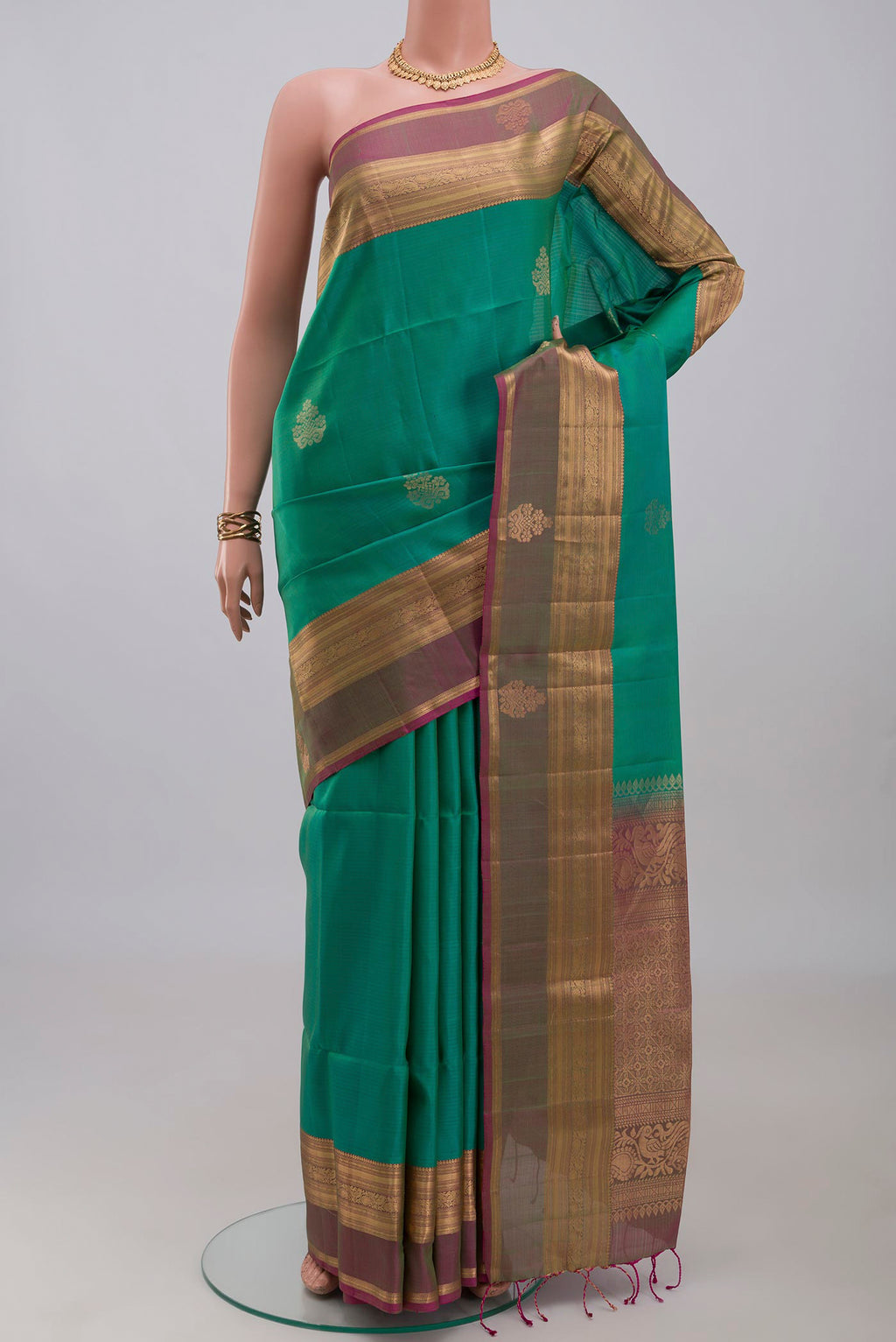 Turquoise Soft Silk Saree with Zari Butta on the body and Zari Border.  displayed on a mannequin
