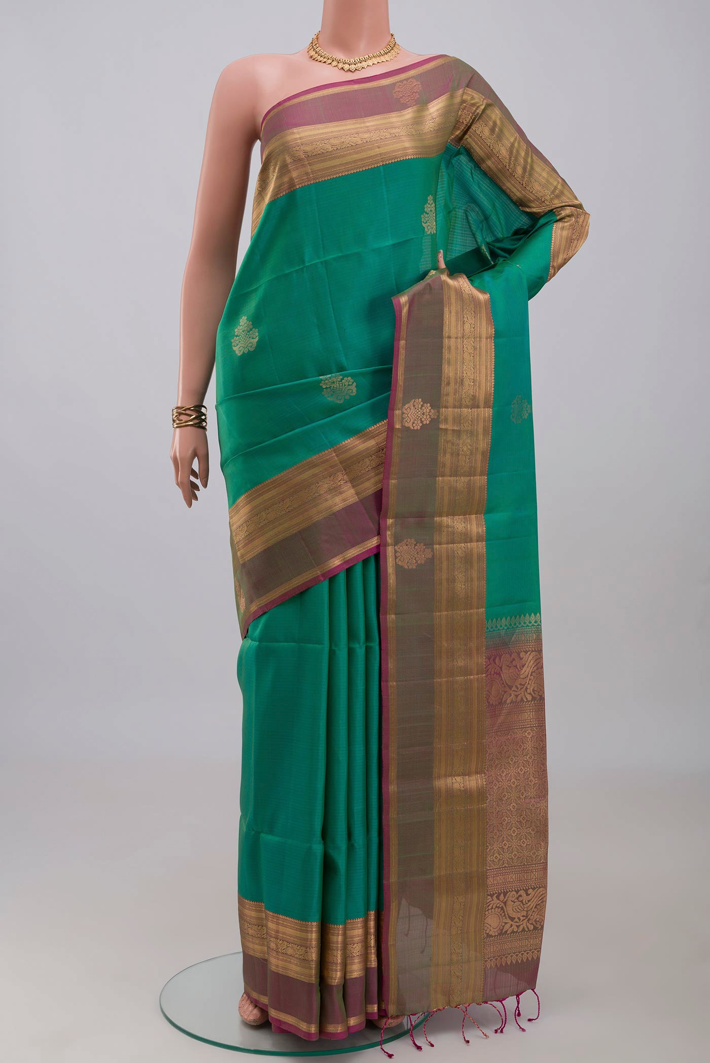 Turquoise Soft Silk Saree with Zari Butta on the body and Zari Border.  displayed on a mannequin