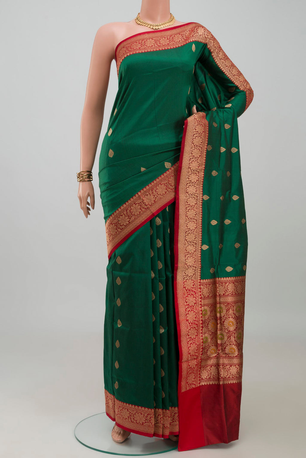 Bottle Green Banarasi Katan Silk Saree with Zari Butta on the body and Fancy Border.  displayed on a mannequin