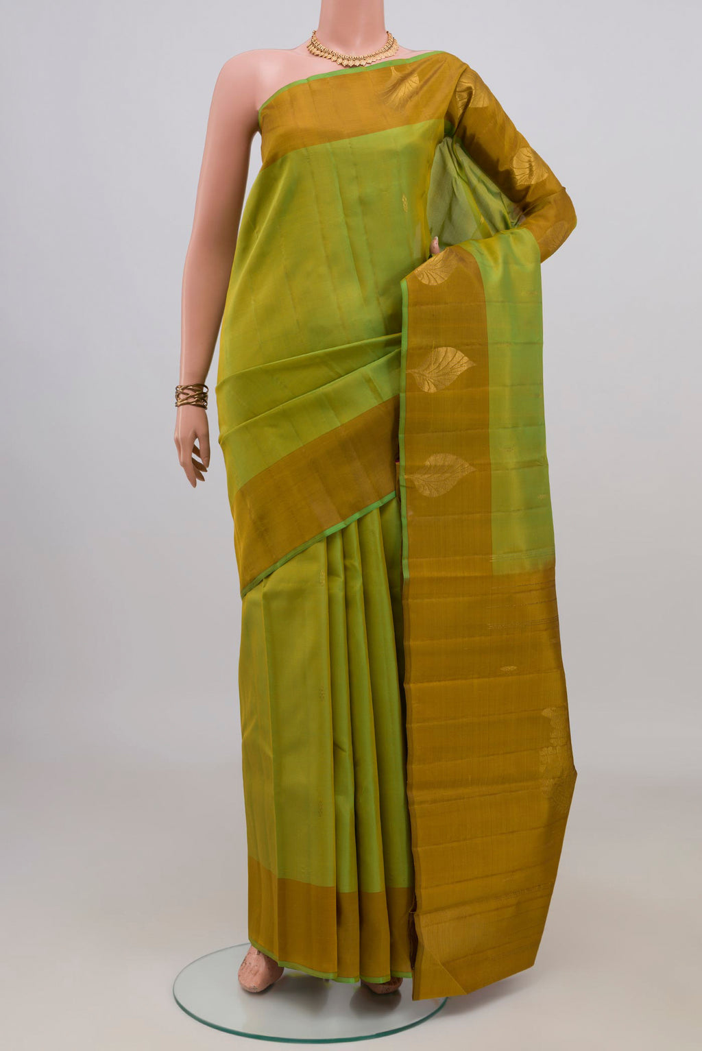 Pure Silk Green Kanchipuram Saree with Zari Butta on the body and Fancy Border.  displayed on a mannequin