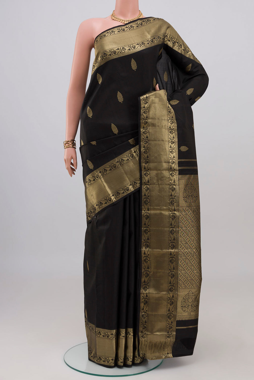 Black Kanchipuram Silk Saree with Zari Butta on the body and Zari Border.  displayed on a mannequin