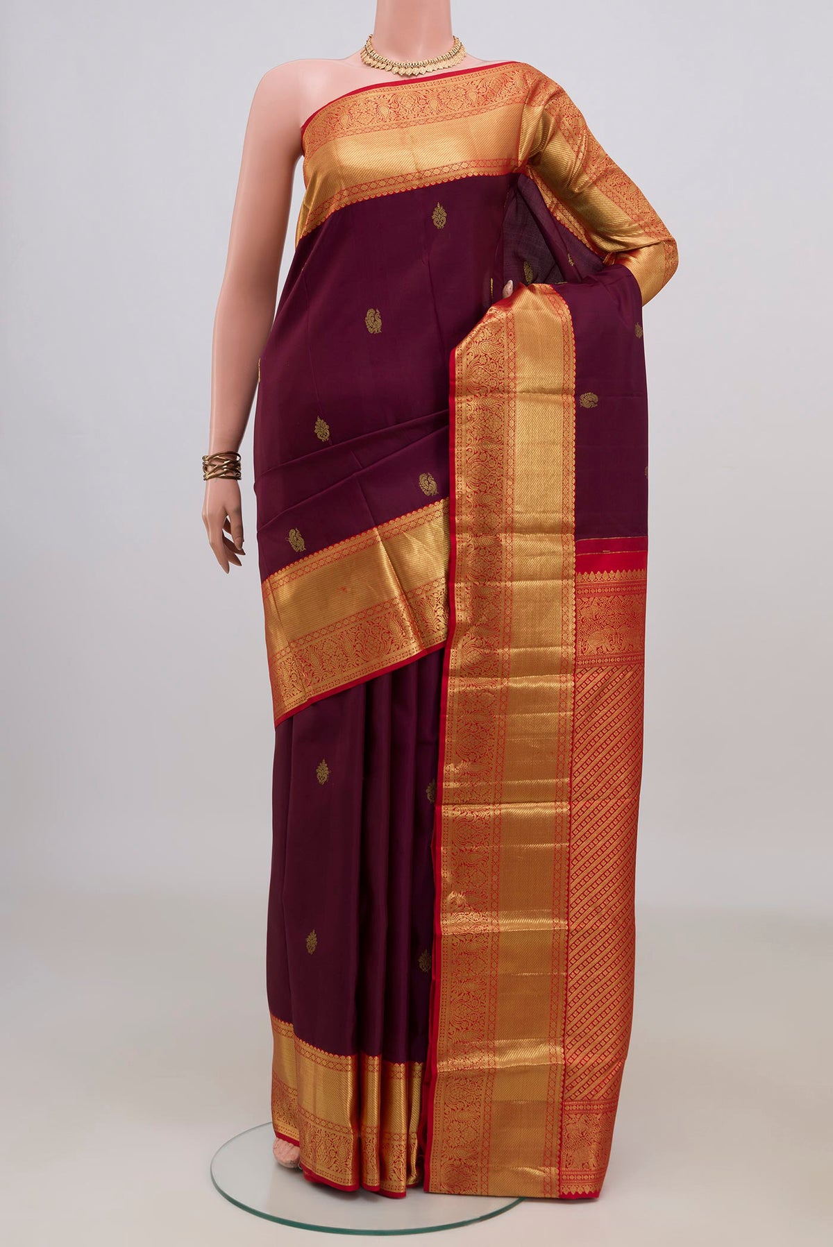 Pure Silk Purple Kanjivaram Saree with Zari Butta on the body and Zari Border.  displayed on a mannequin