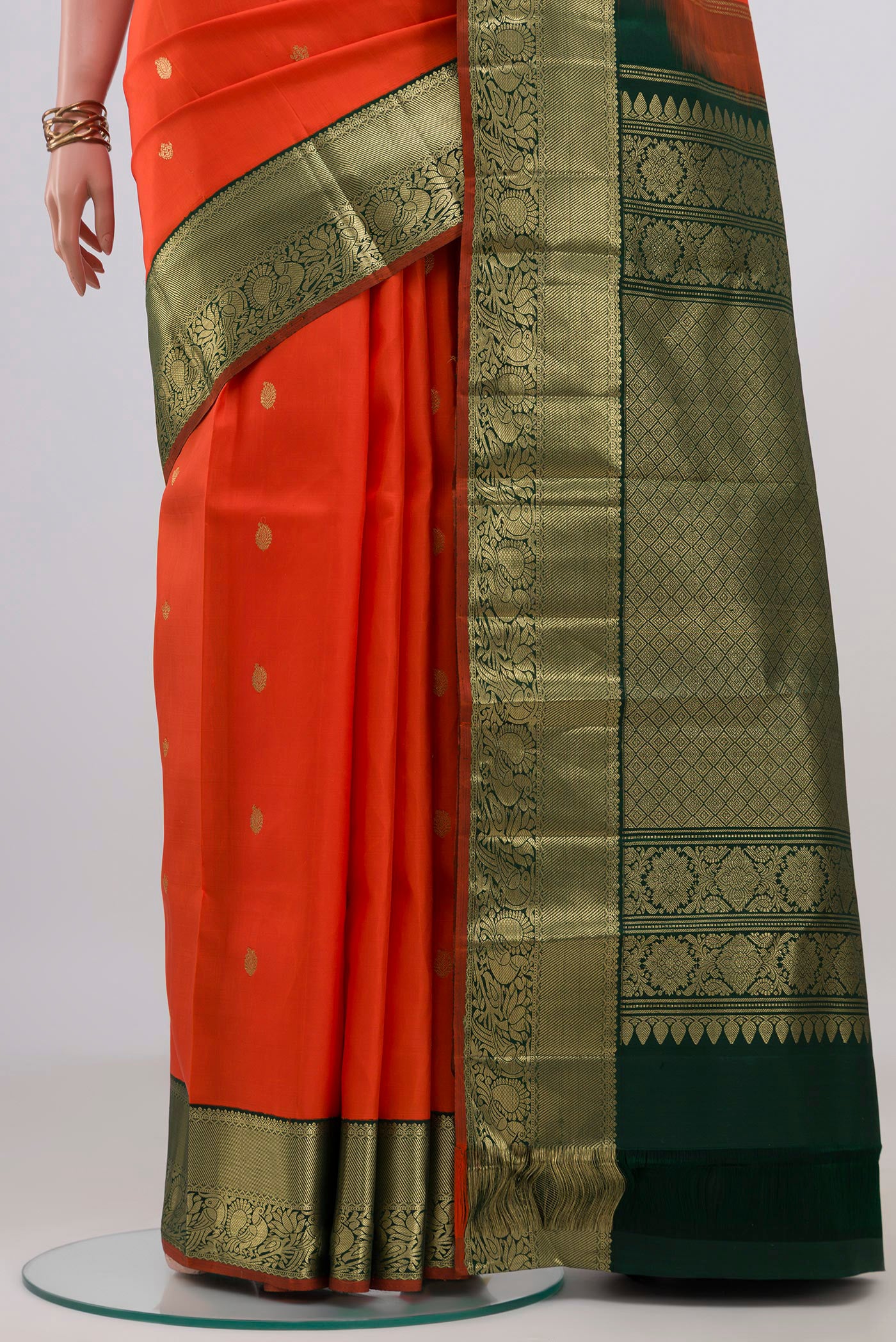 Pleats and pallu of Orange Kanjivaram Silk Saree with Zari Butta on the body and Zari Border. 