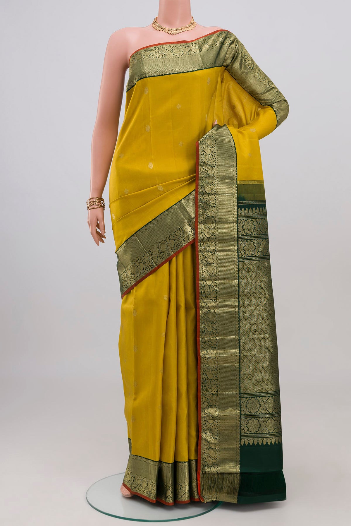 Yellow Kanjivaram Silk Saree with Zari Butta on the body and Zari Border.  displayed on a mannequin