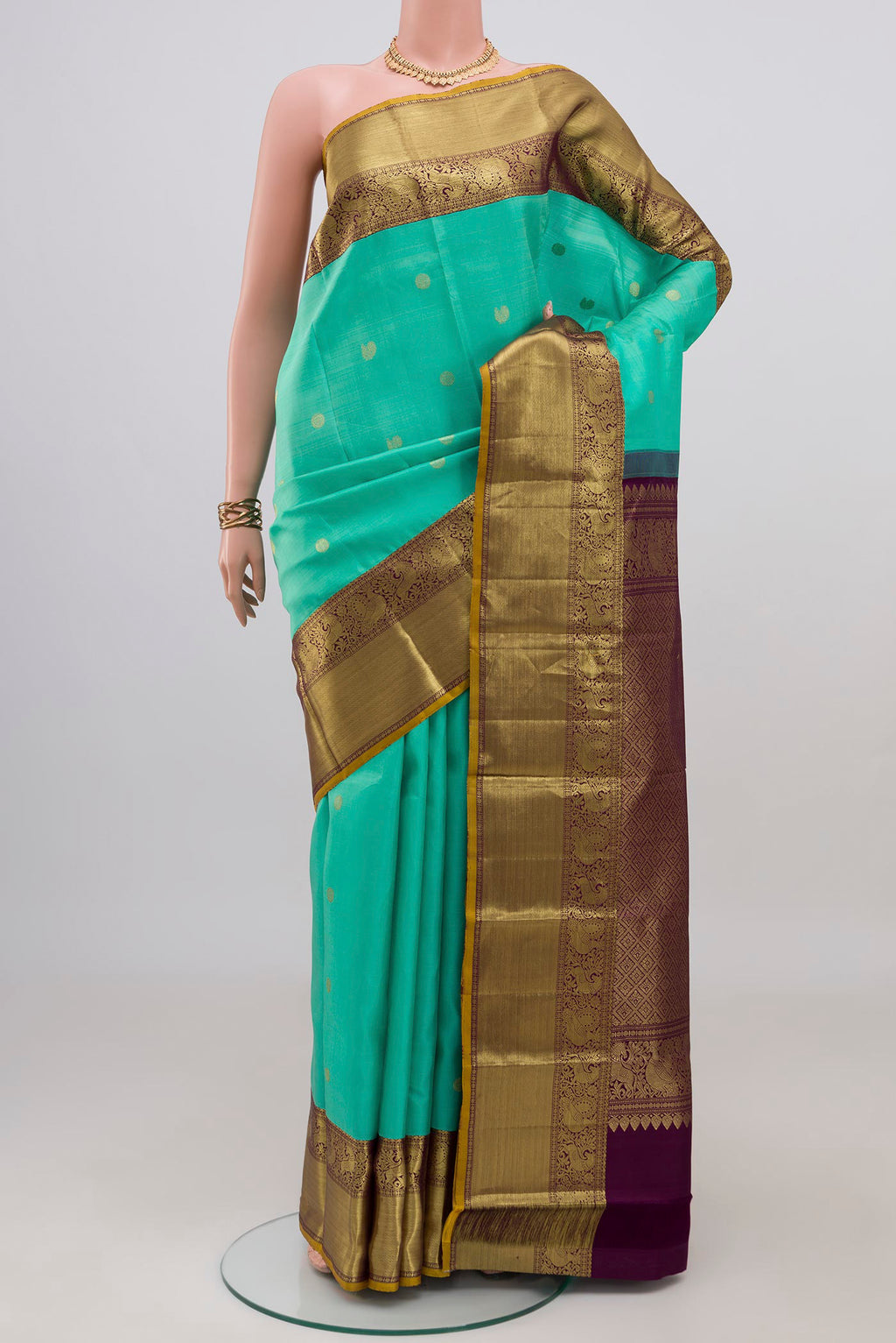 Turquoise Kanjivaram Silk Saree with Zari Butta on the body and Zari Border.  displayed on a mannequin