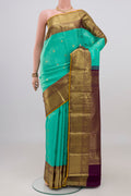 Turquoise Kanjivaram Silk Saree with Zari Butta on the body and Zari Border.  displayed on a mannequin