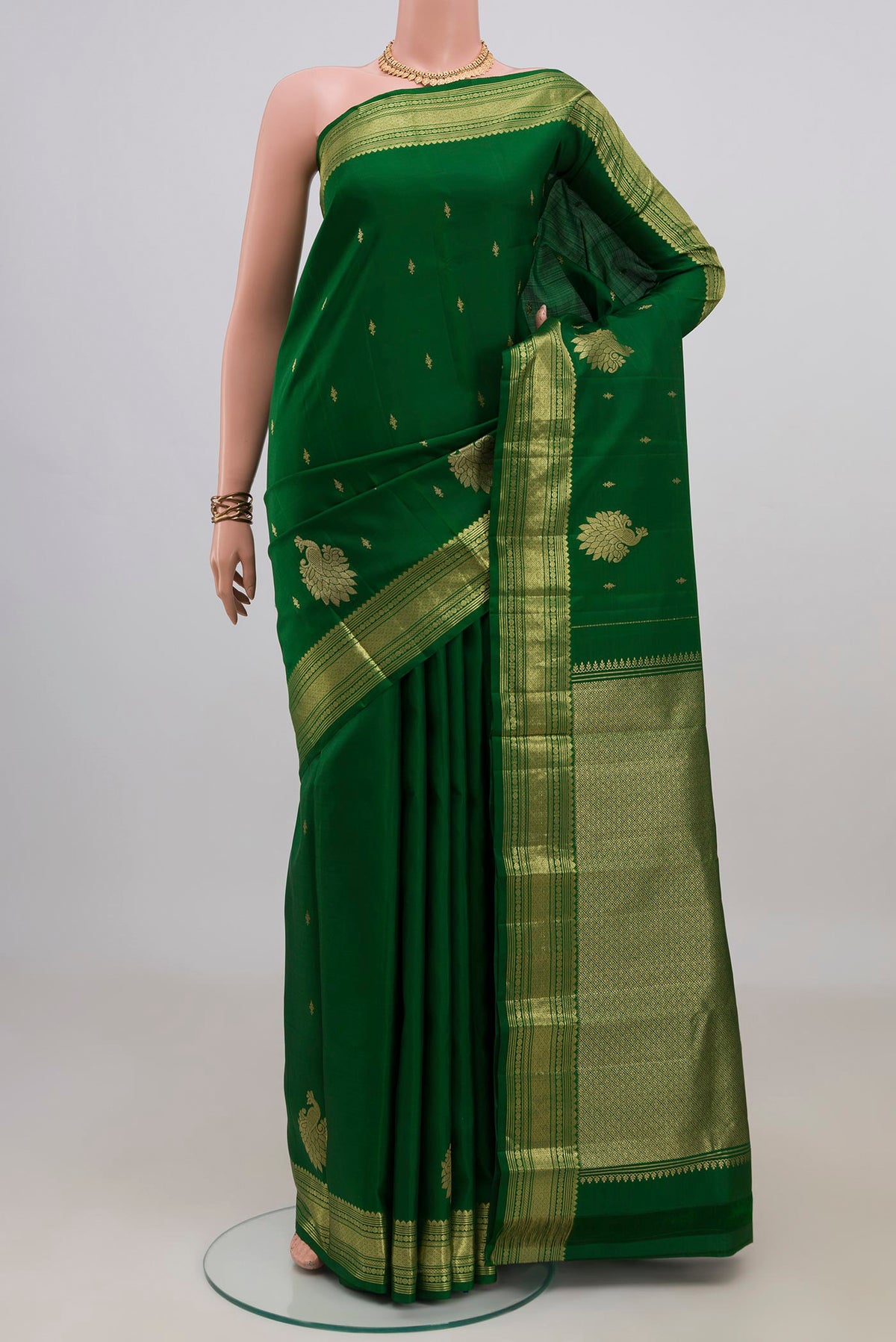 Pure Silk Green Kanjivaram Saree with Zari Butta on the body and Zari Border.  displayed on a mannequin