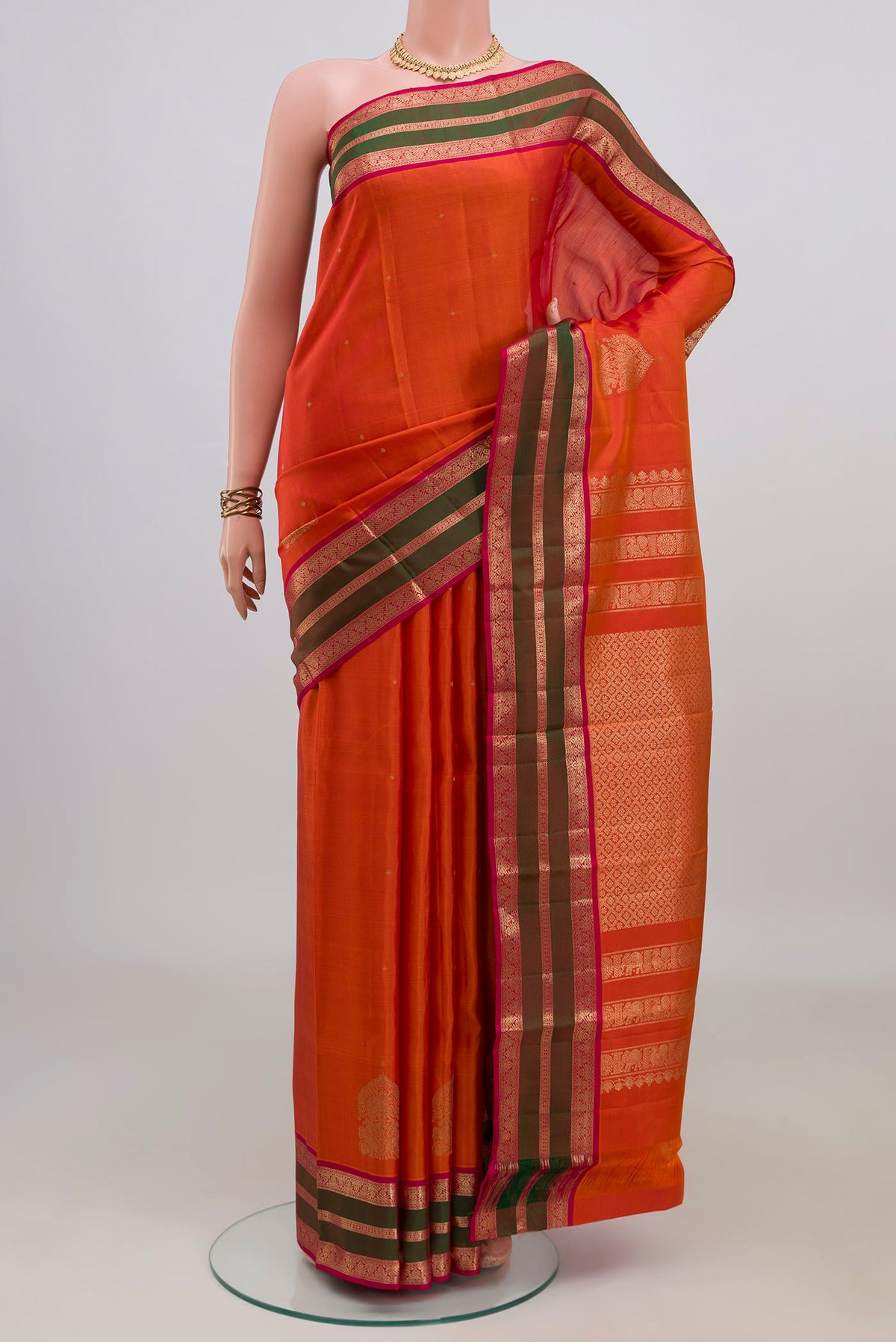 Pure Silk Orange Kanjivaram Saree with Zari Butta on the body and Zari Border.  displayed on a mannequin