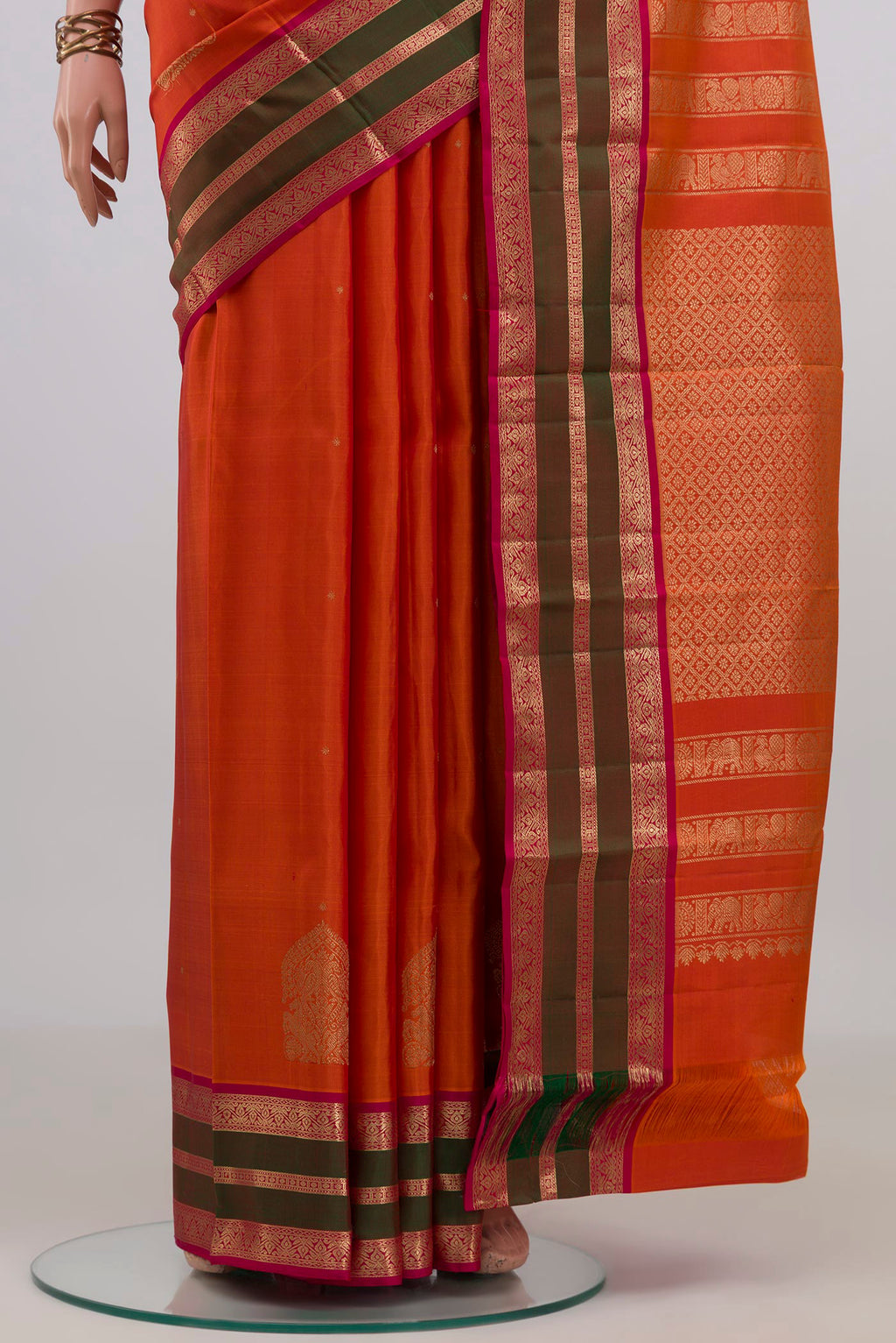 Pleats and pallu of Pure Silk Orange Kanjivaram Saree with Zari Butta on the body and Zari Border. 